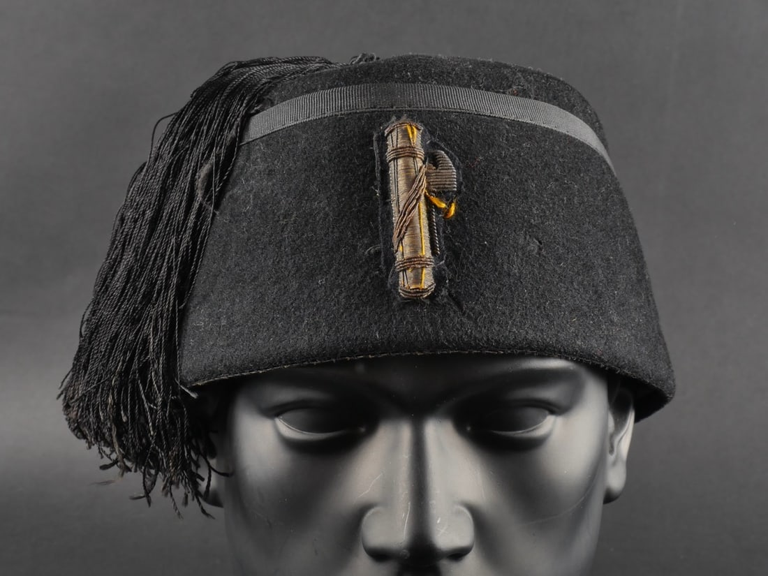 Fez de cadre de la MVSN. MVSN executive fez.: Fez de cadre de la MVSN. En feutre noir avec insigne brode en cannetille or, la hache du faisceau est orientee vers la droite ce qui indique une appartenance a la MVSN, frange et cordelette presente, 