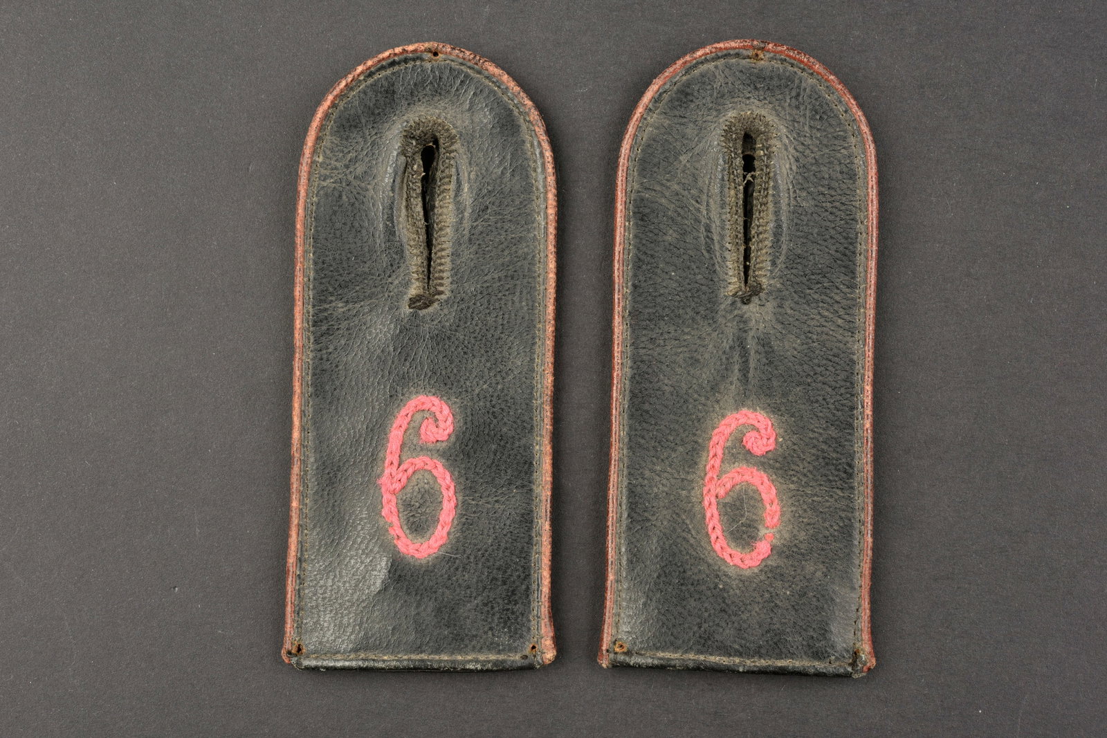 Pattes d epaule Reichswehr. Reichswehr shoulder straps.: Pattes d epaule Reichswehr. Paire homogene en cuir noir. Chiffre 6 brode en fils rose. Lisere rose faisant le tour des pattes d epaules. Completes. Modeles datant des annees 20, probablement pour un m