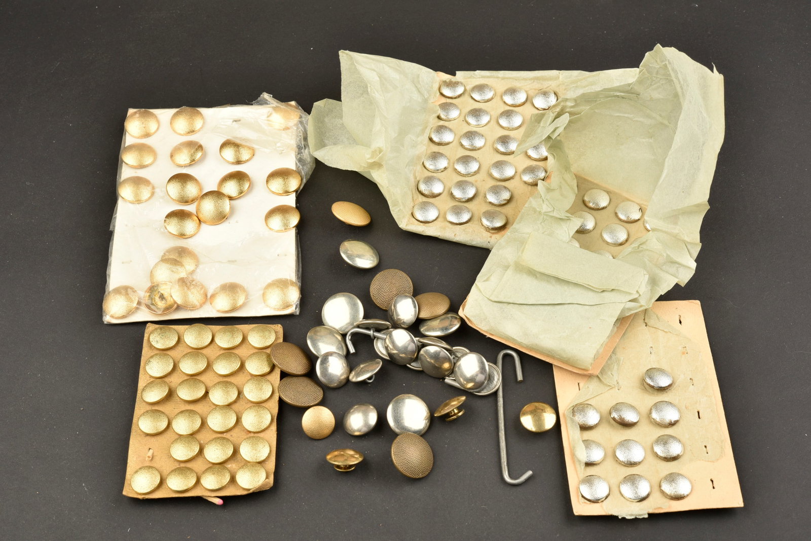 Boutons allemand. German buttons.: Boutons allemand. Comprenant dix petits modeles de boutons, en metal grenele couleur argent, fixes sur le carton d origine, reste de papier d origine. 24 petits boutons, en metal grenele couleur argen