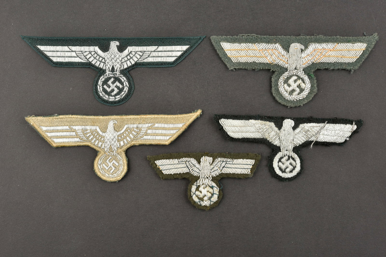Insignes d officier de la Heer. Heer officer badges.: Insignes d officier de la Heer. Comprenant un aigle de coiffure en cannetille argent sur fond vert, visiblement demonte d une coiffure, dos de la piece double de papier noir. Un aigle de poitrine en c