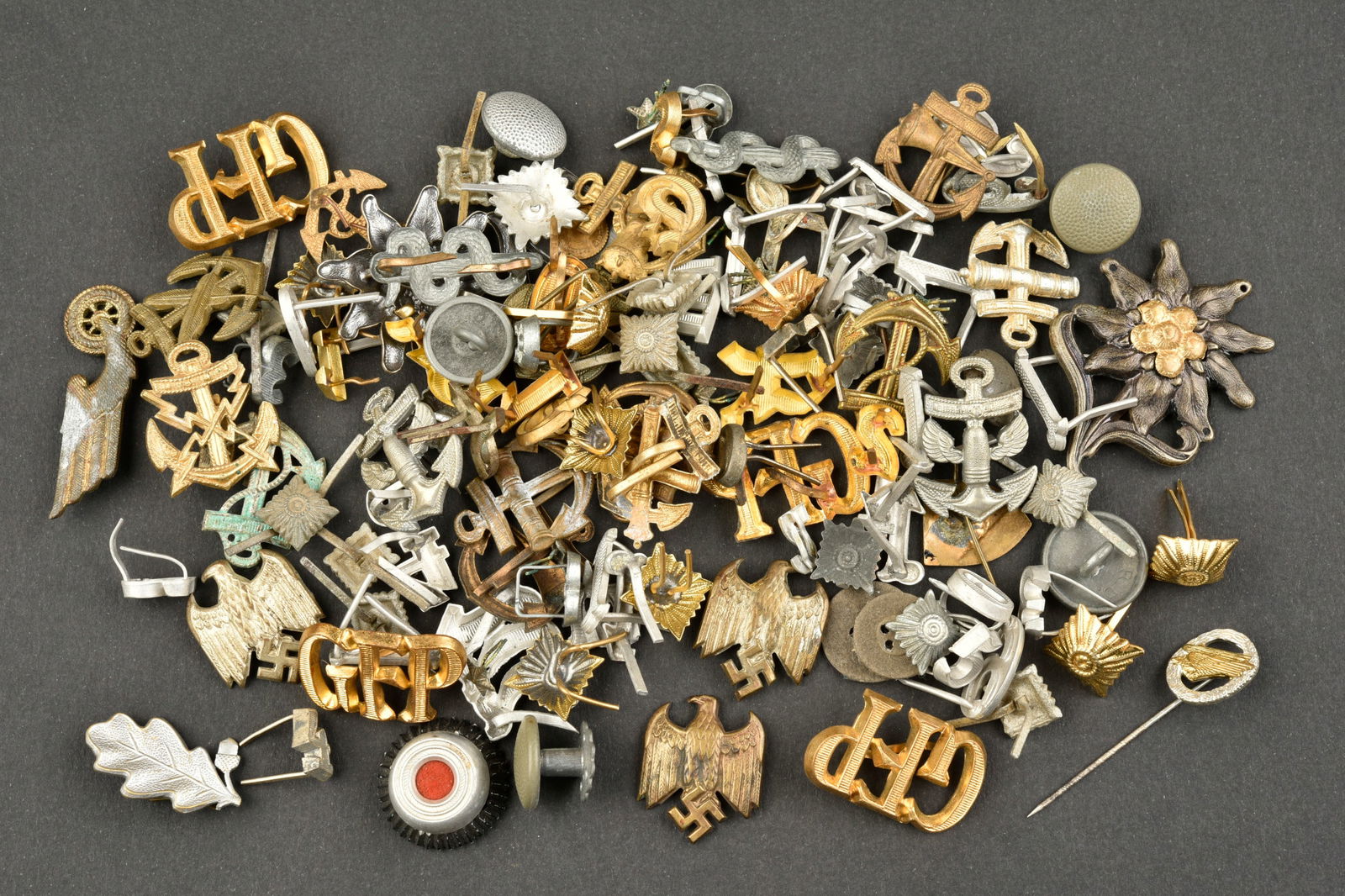 Insignes divers. German insignia.: Insignes divers. Comprenant des clous de grade. Des lettres pour pattes d epaule. Deux edelweiss des Gebirgsjager. Des boutons. A noter une certaine usure et patine des pieces. Etat II+. Various badge