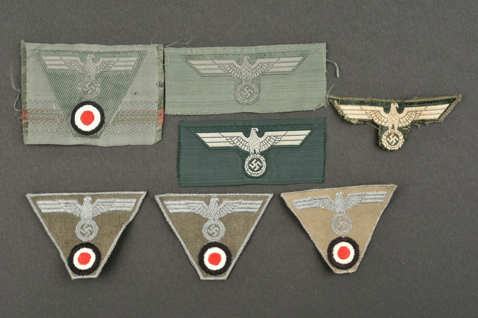 Aigle de coiffure Heer. Heer headdress eagle.: Aigles de coiffure Heer. Comprenant sept insignes pour coiffure. Divers modeles et fabrication. A noter une certaine usure et patine des pieces. Etat II+. Heer headgear eagles. Comprising seven headge