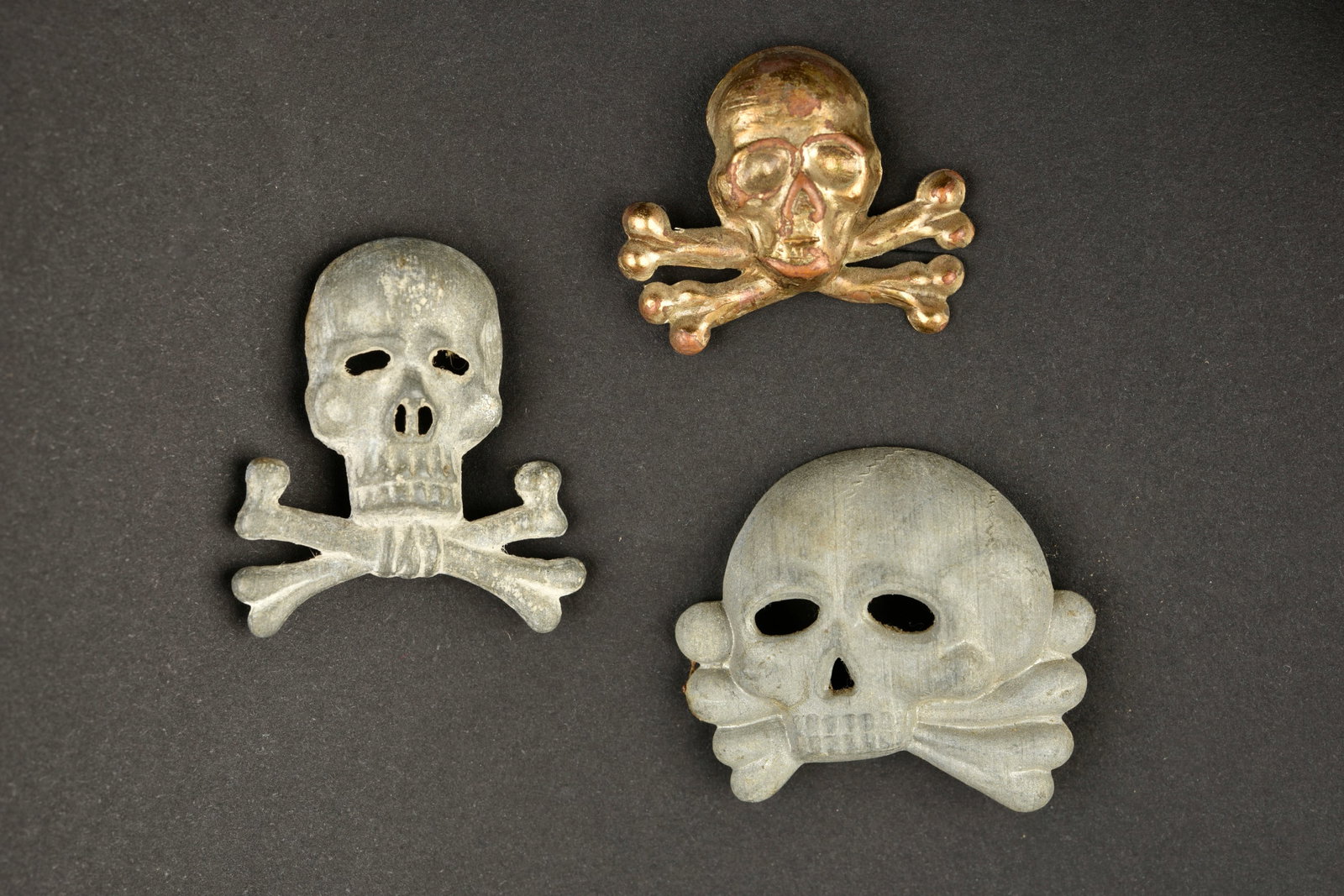 Tetes de mort cavalerie. Cavalry skulls.: Tetes de mort cavalerie. Trois modeles differents de tetes de mort pour casquette de cavalerie, sans marquages visibles. Une attache est manquante. A noter une certaine usure et patine des pieces. Eta