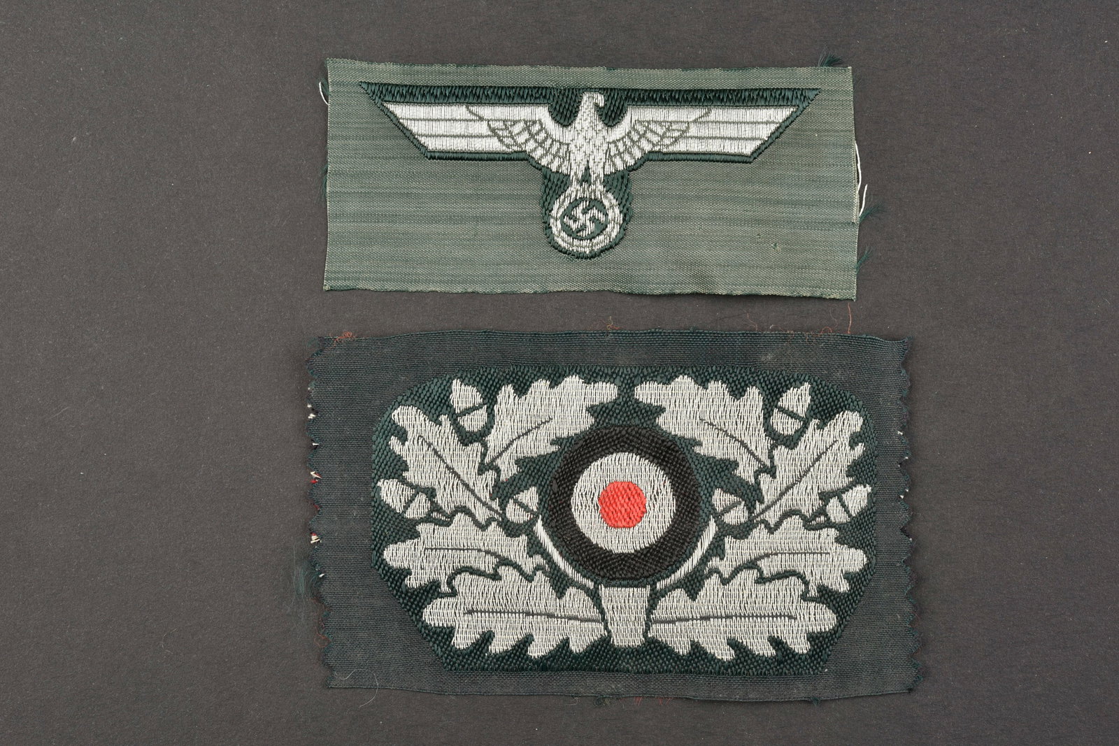 Insignes de coiffure de la Heer. Heer headgear badges.: Insignes de coiffure de la Heer. Comprenant un aigle Bevo, jamais monte. Des feuilles de chene et cocarde Bevo, pour casquette Alter Art. Jamais montees. A noter une legere usure et patine des pieces.
