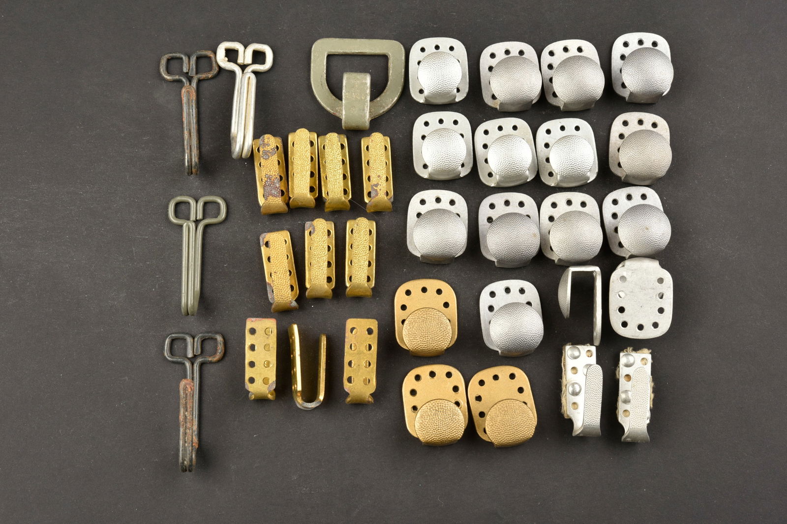 Crochets d uniformes. Uniform hooks.: Crochets d uniforme. Comprenant 35 crochets. Divers modeles et tailles. A noter une certaine usure et patine des pieces. Etat II+. Uniform hooks. Includes 35 hooks. Various models and sizes. Some wear