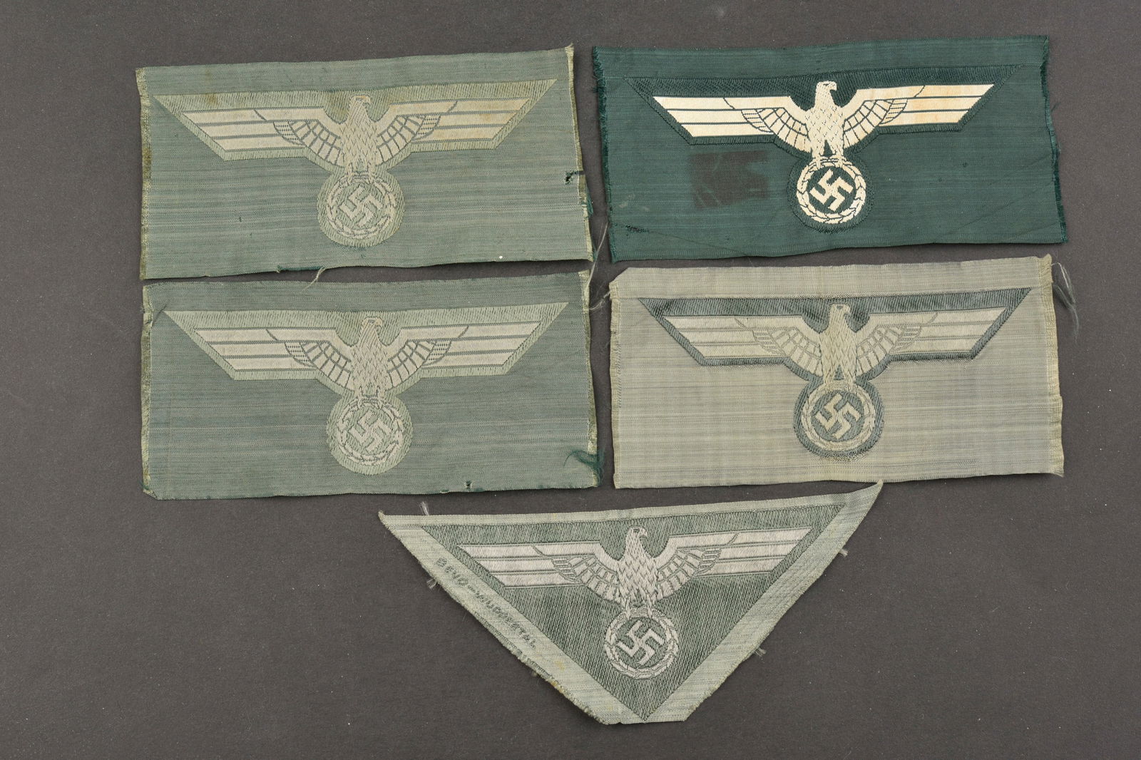 Aigles de poitrine Heer. Heer breast eagles.: Aigles de poitrine Heer. Comprenant cinq aigles Bevo, jamais montes. Divers modeles. A noter une certaine usure et patine des pieces, ainsi que des taches et traces de colle au dos. Etat II+. Heer bre