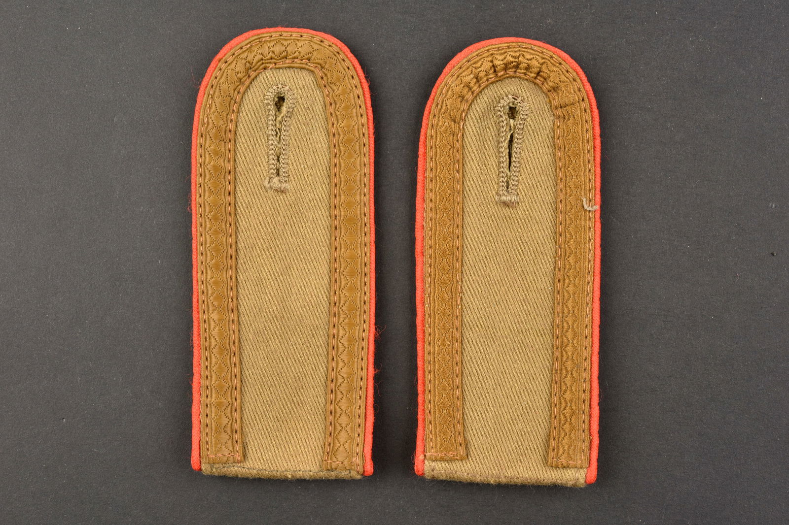Pattes d epaule AK. AK shoulder straps.: Pattes d epaule Afrikakorps. Paire homogene en tissu coton beige, lisere rouge de l artillerie. Dos des pieces double en tissu beige. Grade d Unteroffizier. L authenticite des pieces n est pas garanti