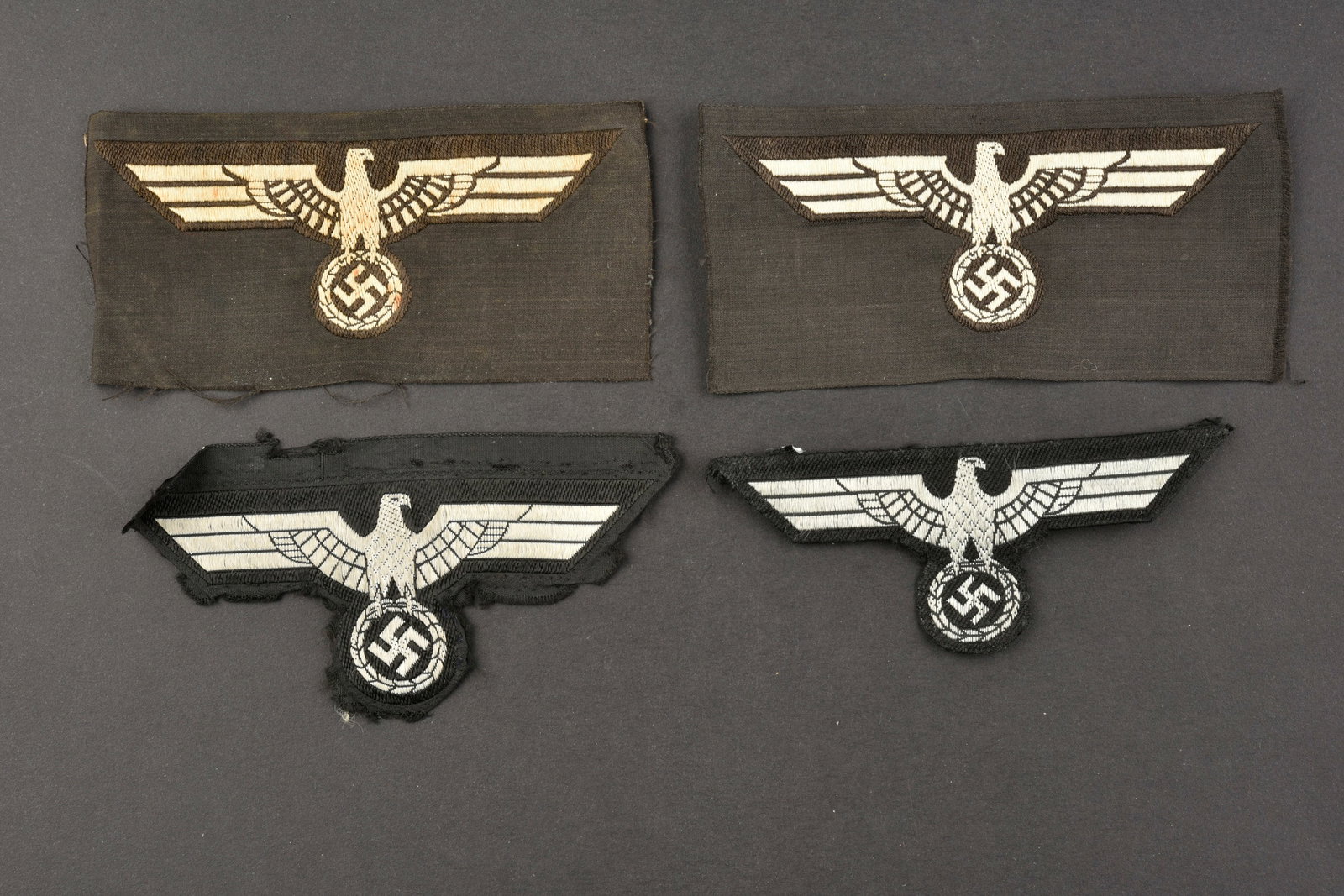Aigles de poitrine Panzer. Panze breast eagle.: Aigles de poitrine Panzer. Comprenant quatre aigles tisse sur fond noir. Divers modeles. Deux aigles sont demontes d une vareuse. A noter une certaine usure et patine des pieces, ainsi que des ta ches