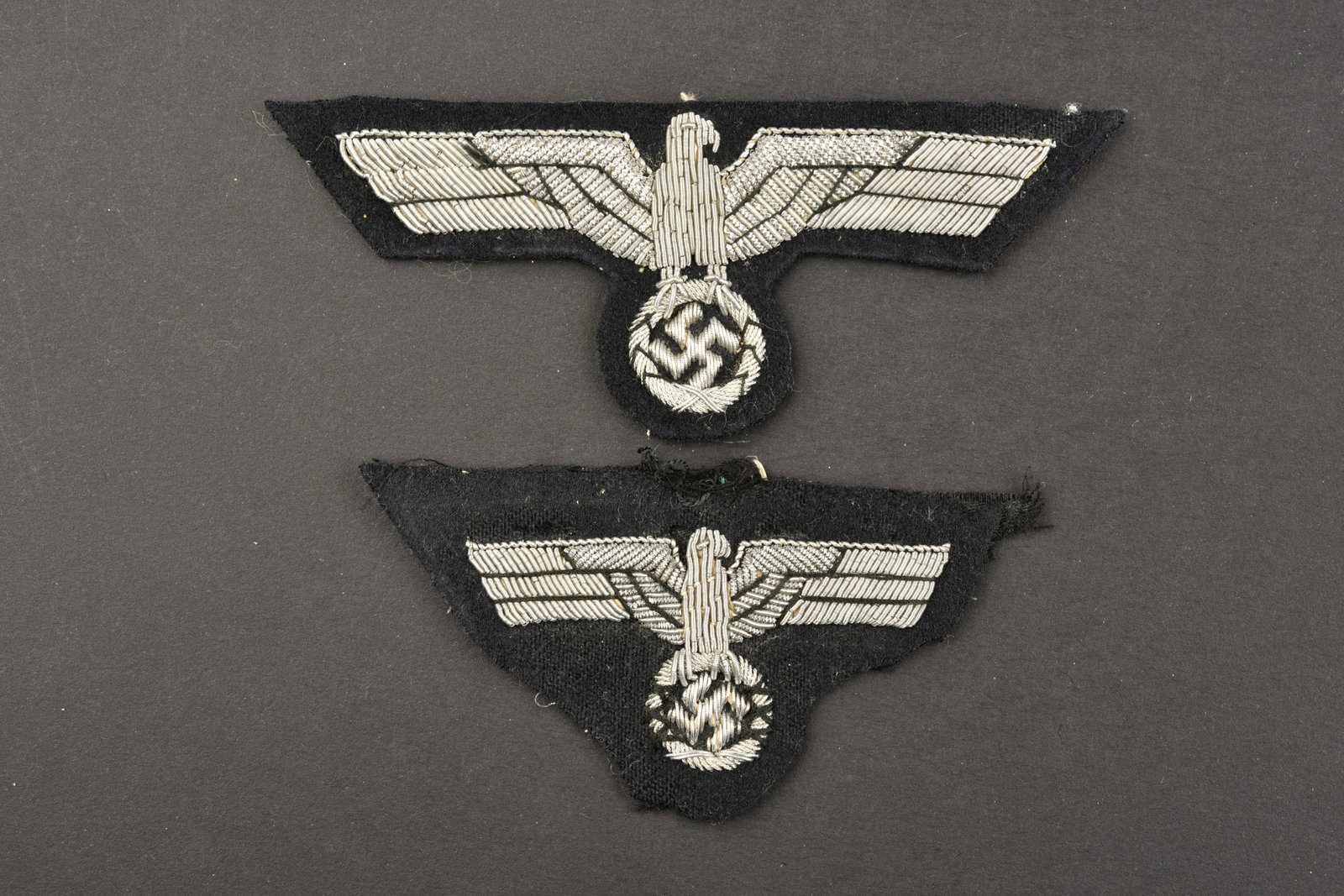 Insignes Panzer. Panzer insignia.: Insignes d officier Panzer. Comprenant un aigle de poitrine en cannetille argent sur fond en drap noir, dos de la piece double en papier. Un aigle de coiffure en cannetille argent sur fond en drap noi