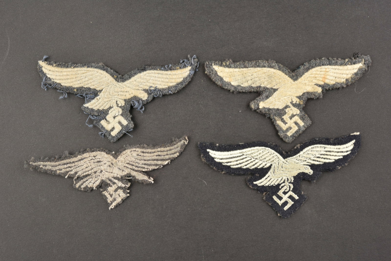 Aigles de poitrine LW. LW breast eagles.: Aigles de poitrine de la Luftwaffe. Comprenant un aigle brode sur fond gris/bleu, visiblement demonte d une vareuse. Un aigle brode monte sur tissu gris, visiblement demonte d une vareuse. Un aigle br