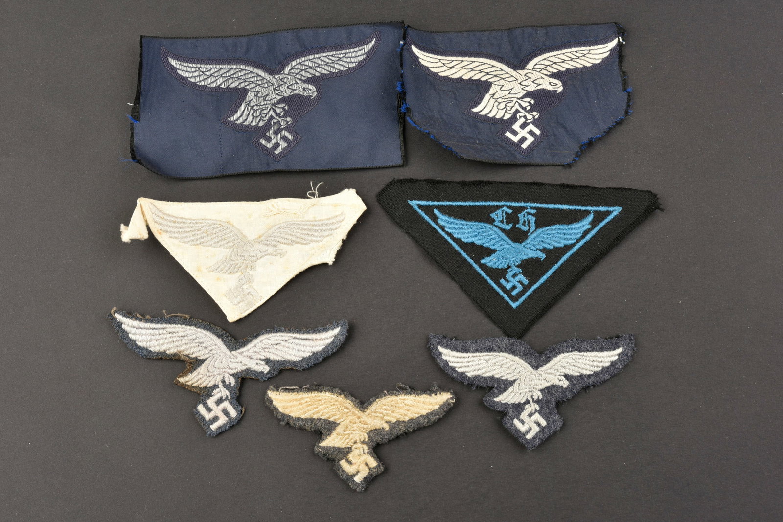 Insignes Luftwaffe. Luftwaffe insignia.: Insignes de la Luftwaffe. Comprenant un aigle de poitrine brode sur fond blanc, visiblement demonte d une vareuse. Un aigle Bevo, jamais monte. Un aigle de coiffure brode, visiblement demonte d une co
