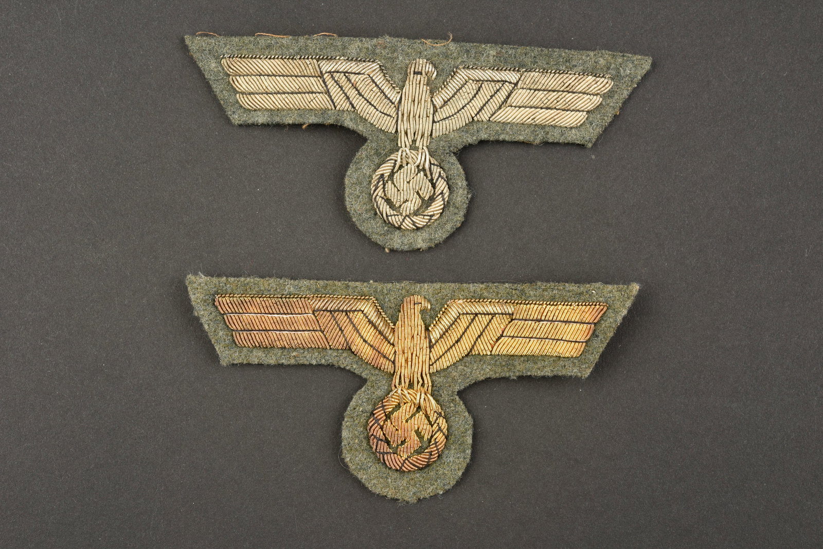 Aigles de poitrine artillerie cotiere. Coastal artillery breast eagles.: Aigles de poitrine artillerie cotiere. Comprenant un aigle en cannetille or sur fond en drap Feldgrau, jamais monte, dos de la piece double en tissu blanc. Un aigle de poitrine en cannetille argent su