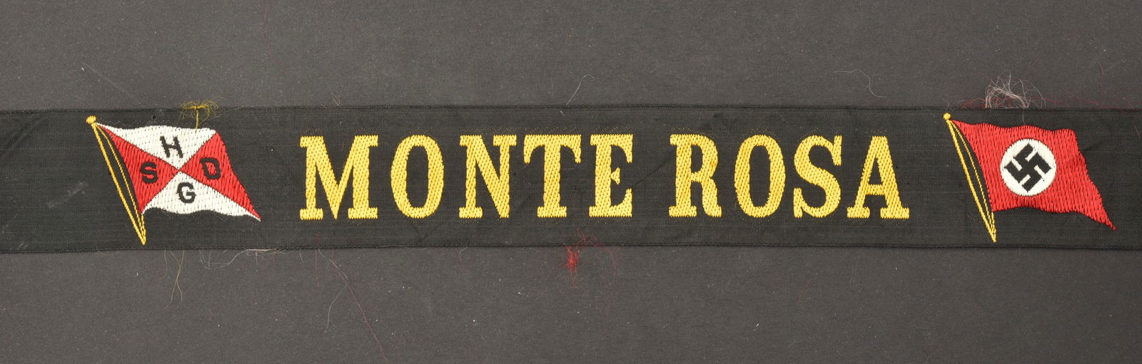 Bande de ba chi Monte Rosa. Monte Rosa band.: Bande de ba chi Monte Rosa. En tissu noir, tissage jaune marque Monte Rosa avec un drapeau allemand et un autre marque HSGD. Longueur 92 cm. A noter une certaine usure et patine de la piece, ainsi que