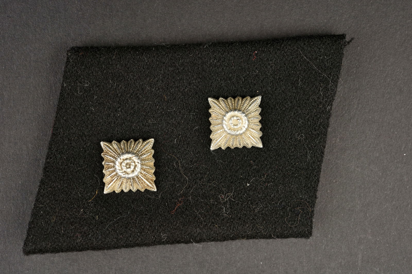 Patte de col SS. SS collar tabs.: Patte de col SS. En drap noir, deux clous de grade metallique, correspondant au grade d Oberscharfuhrer. A noter une certaine usure et patine de la piece. Etat II+. SS collar tab. In black cloth, two