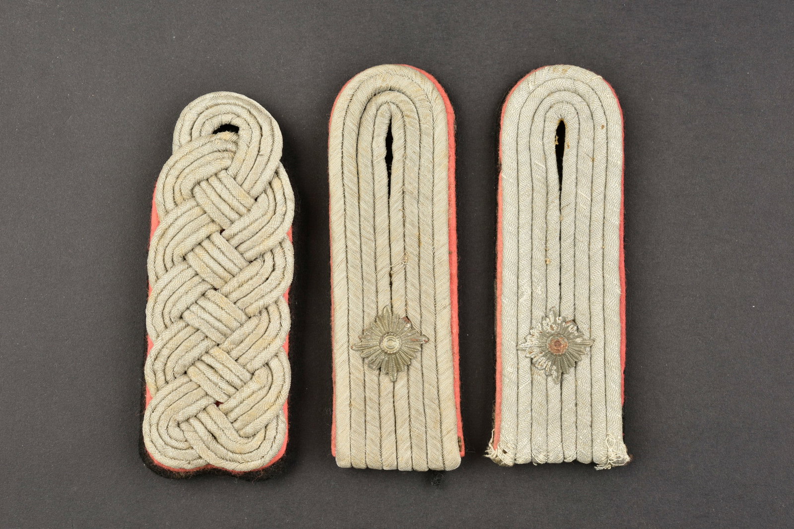 Pattes d epaule SS. SS shoulder strap.: Pattes d epaule SS. Comprenant une patte d epaule de Sturmbannfuhrer des unites blindees. Une paire non homogene de patte d epaule d Obersturmfuhrer, des unites blindees. A noter une certaine usure et