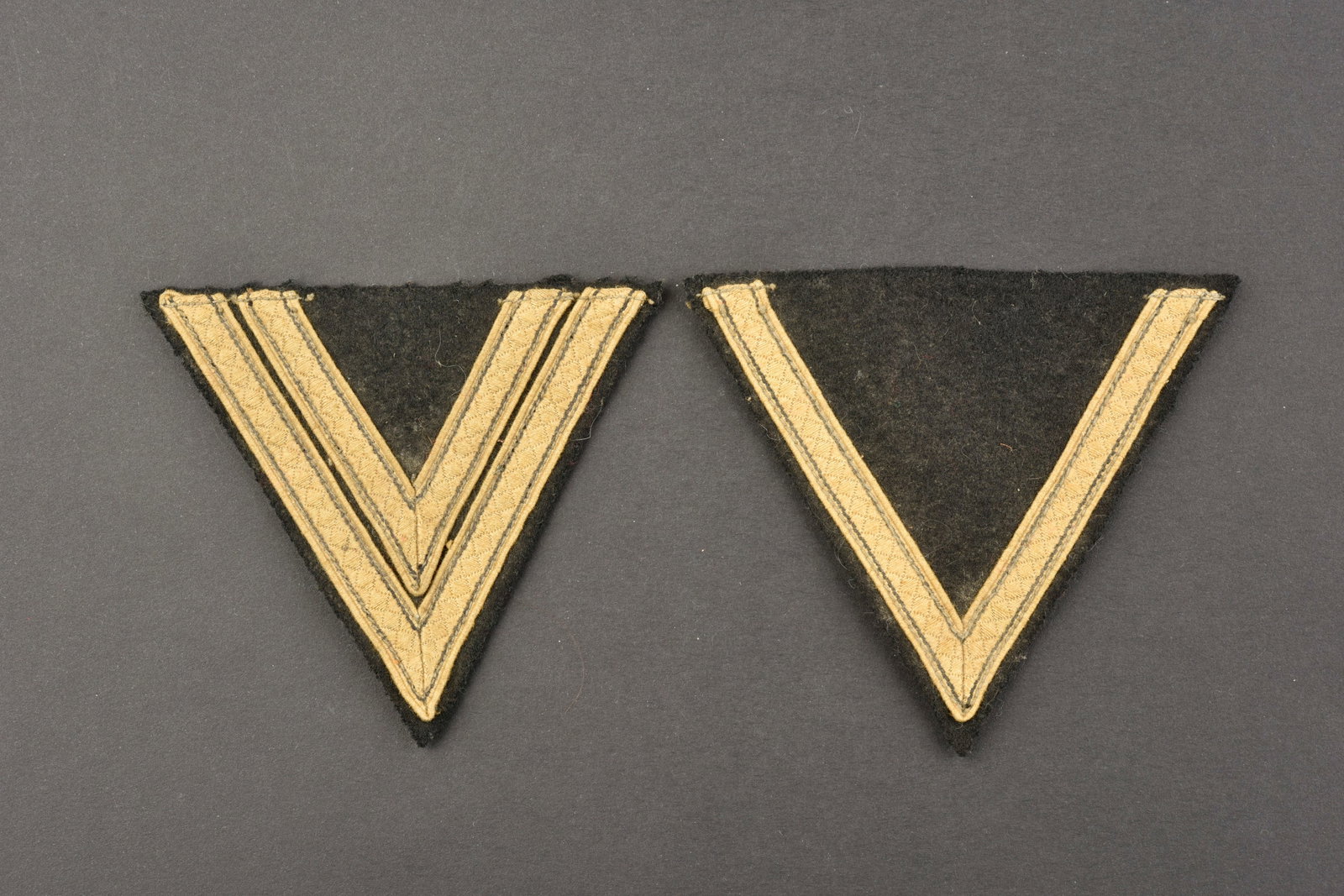 Grades de manche SS. SS sleeve grade.: Grades de manche SS ou Panzer Wehrmacht. Insignes de bras pour SS Sturmmann ou Gefreiter et SS Rottenfuhrer ou Obergefreiter. En drap noir et galon argent. A noter une certaine usure et patine des pie