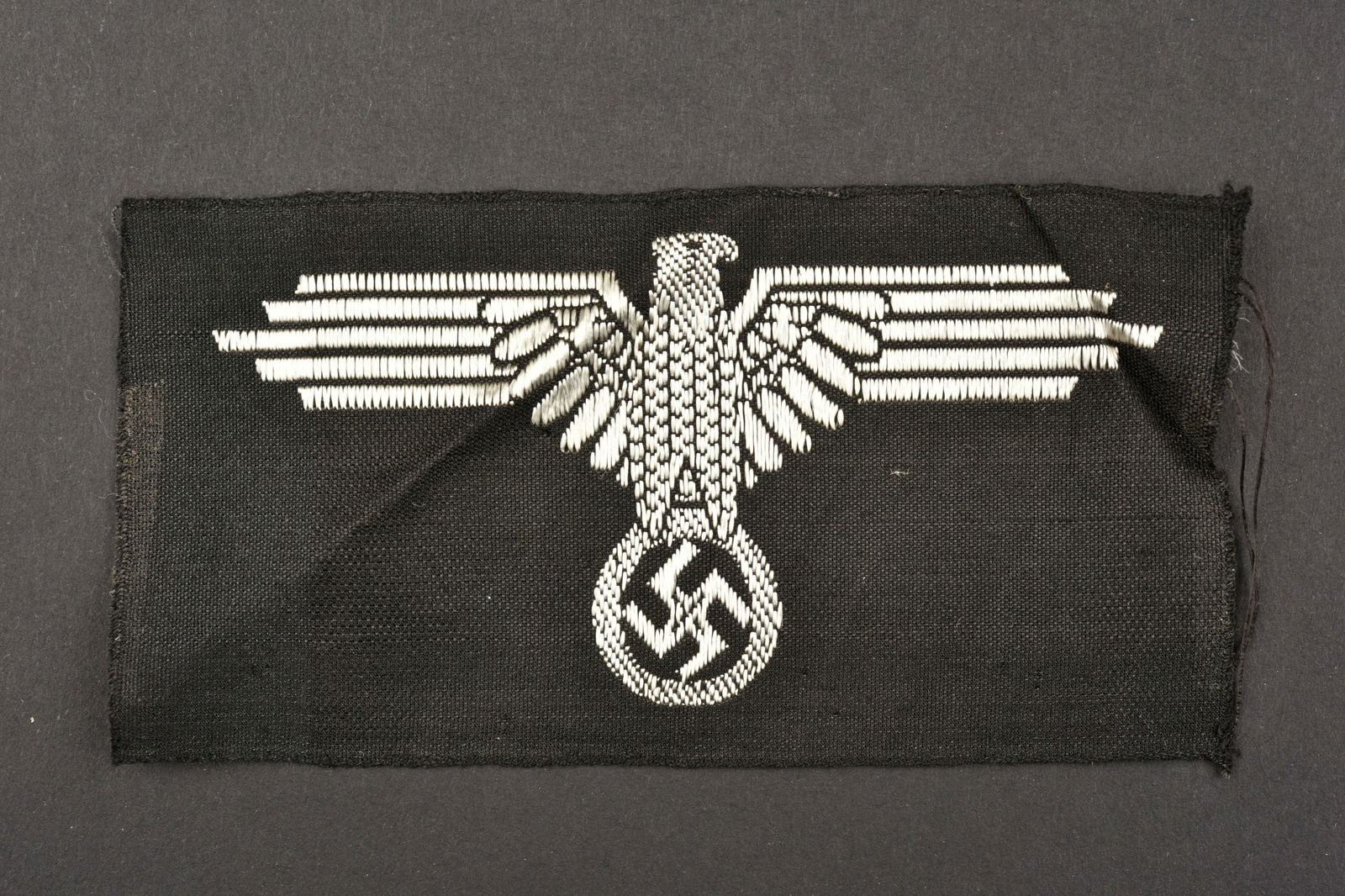 Aigle de manche SS. SS sleeve eagle.: Aigle de manche SS. Modele Bevo, jamais monte. Fabrication belge. A noter une certaine usure et patine de la piece. Etat II+. SS sleeve eagle. Bevo model, never mounted. Made in Belgium. Some wear and