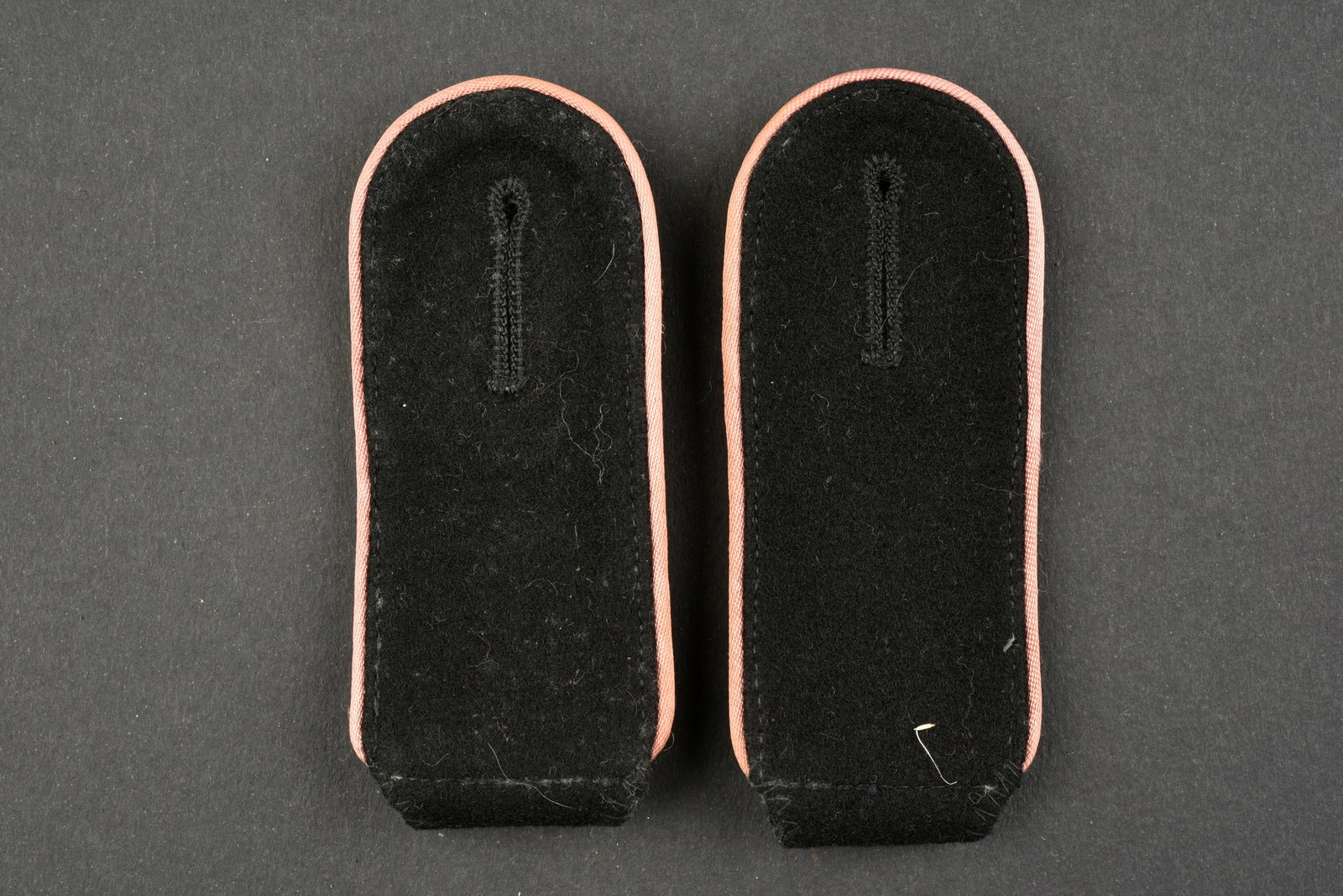 Pattes d epaule Panzer SS. Panzer SS Shoulder strap.: Pattes d epaule Panzer SS. Paire homogene en drap noir, lisere rose, doublure en drap Feldgrau. A noter une certaine usure et patine des pieces, ainsi que quelques ta ches et traces de mite. Etat II+.