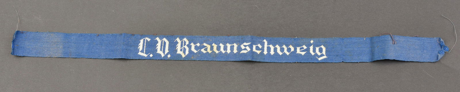 Bande de bras Braunschweig. Braunschweig cufftittle.: Bande de bras LV Braunschweig. En tissu bleu, broderie blanche. Marquages LD Braunschweig. Longueur 38 cm. A noter une certaine usure et patine de la piece, ainsi que des ta ches. Etat II+. LV Braunsc