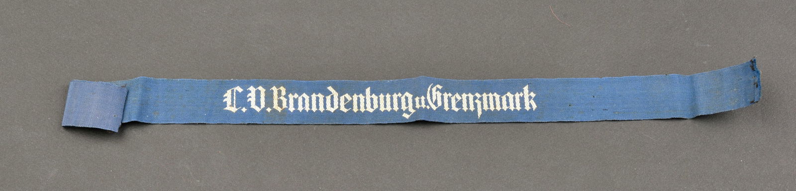 Bande de bras Stalhelm. Der Stahlhelm armband.: Bande de bras Stalhelm. Modele pour la branche feminine du Stalhelm. Bande de manche de couleur bleue tissee machine LV Brandenburg u Grenzmark. Longueur 37,5 cm. Incomplete. A noter une certaine usur