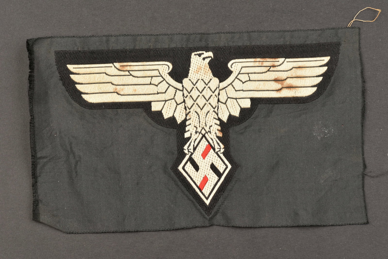 Insigne de maillot de sport etudiants du Reich. Reich student sports jersey badge.: Insigne de maillot de sport de l'association des etudiants du Reich. Modele d'aigle tisse sur fond en tissu noir, jamais monte. A noter une certaine usure et patine de la piece, ainsi que quelques tra
