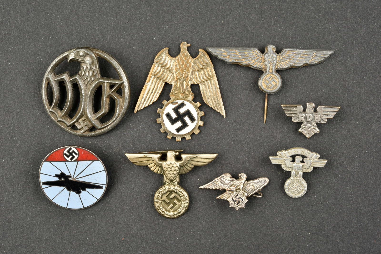 Insignes divers. Miscellaneous badges.: Insignes divers. Comprenant un insigne en metal WB, attache complete, marquages illisibles au dos. Un aigle de coiffure, attache complete. Un insigne en metal emaille, attache complete, marquages au d