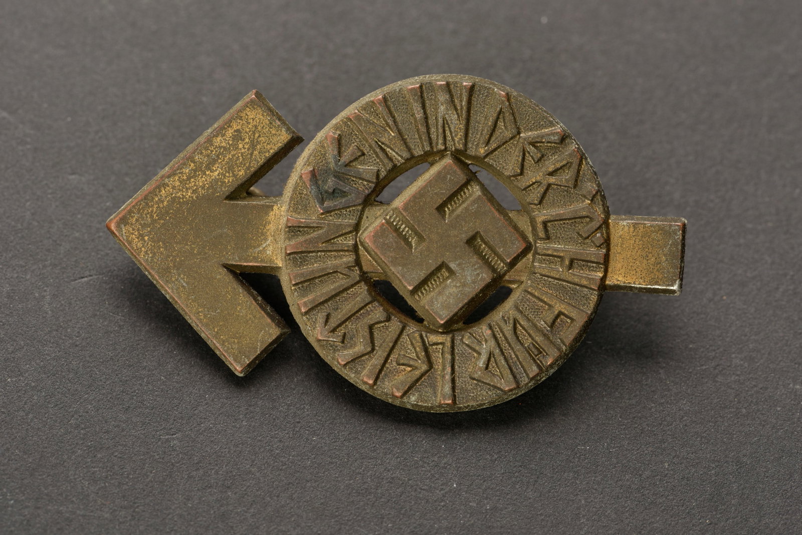 Leistungen HJ.: Fur Leistungen der Hitlerjugend. Modele en metal leger, couleur bronze a 10%. Attache complete. Fabrication RZM M1/101, correspondant au fabricant Gustav Brehmer, Markneukirchen. Numero 45918. Attache