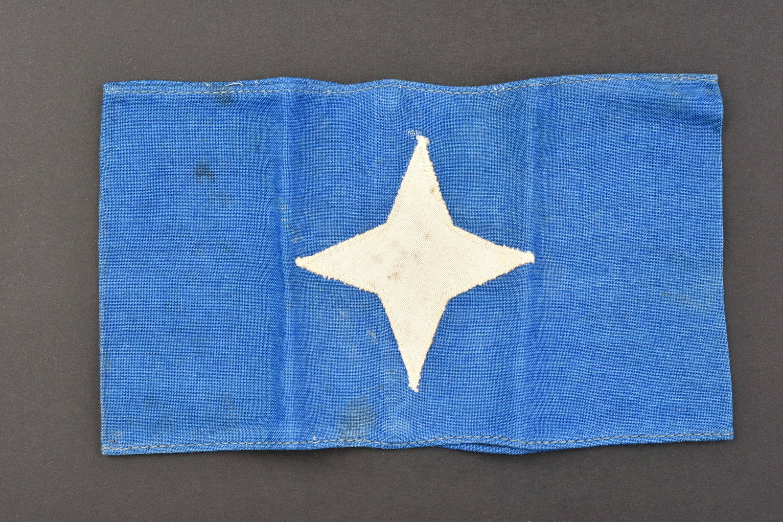 Brassard Luftschutz. Luftschutz armband.: Brassard Luftschutz. En tissu coton bleu, etoile blanche rapportee. Modele pour Luftschutz Stellvertretender Betriebsluftschutzfuhrer. A noter une certaine usure et patine de la piece, ainsi que quelq