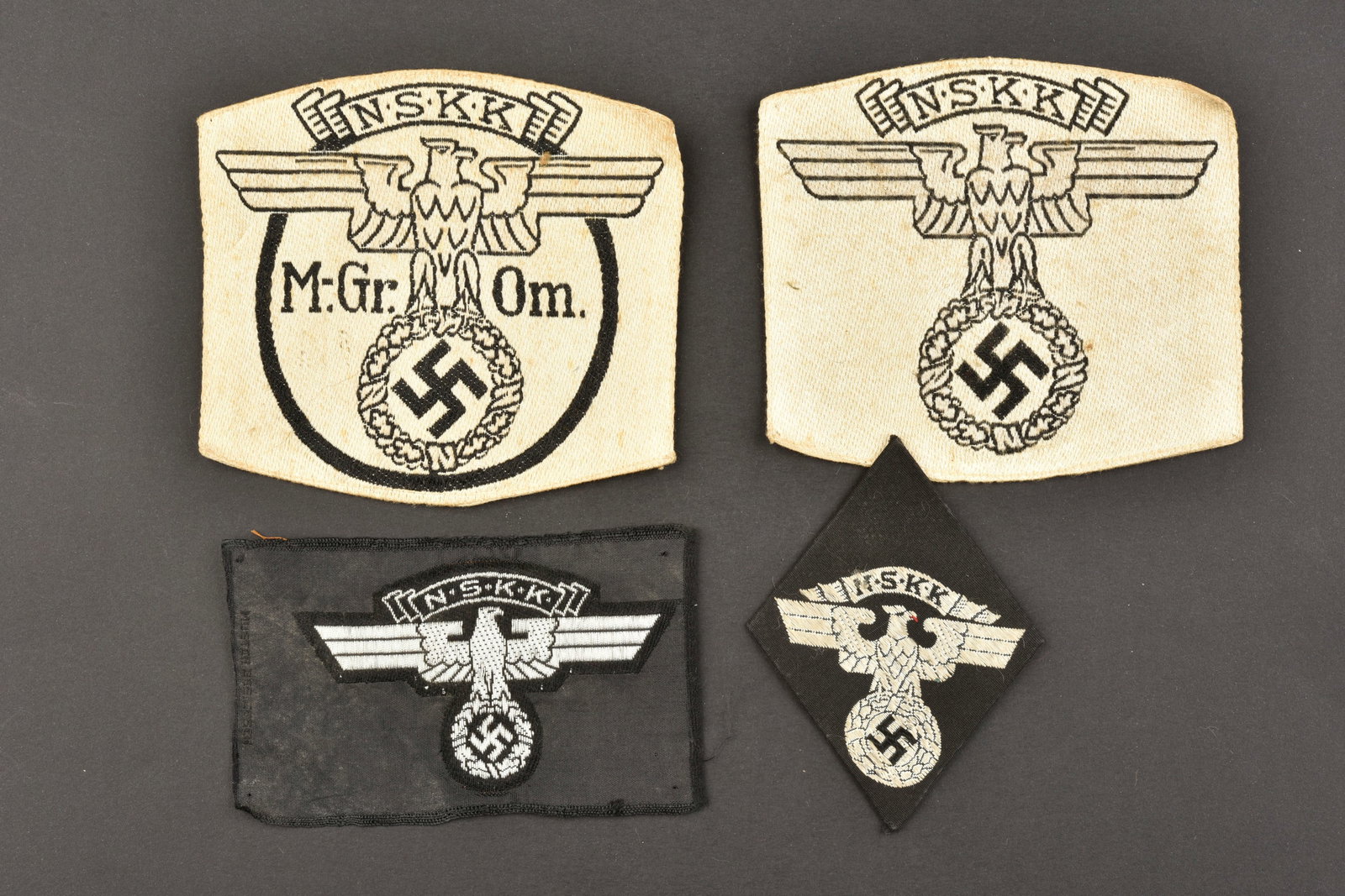 Insignes NSKK. NSKK insignia.: Insignes NSKK. Comprenant un insigne en forme de losange, tisse de l'aigle NSKK, dos cartonne. Un insigne jamais monte Bevo NSKK, etiquette RZM numero 057969, code fabricant RZM A4/374. Un insigne de 