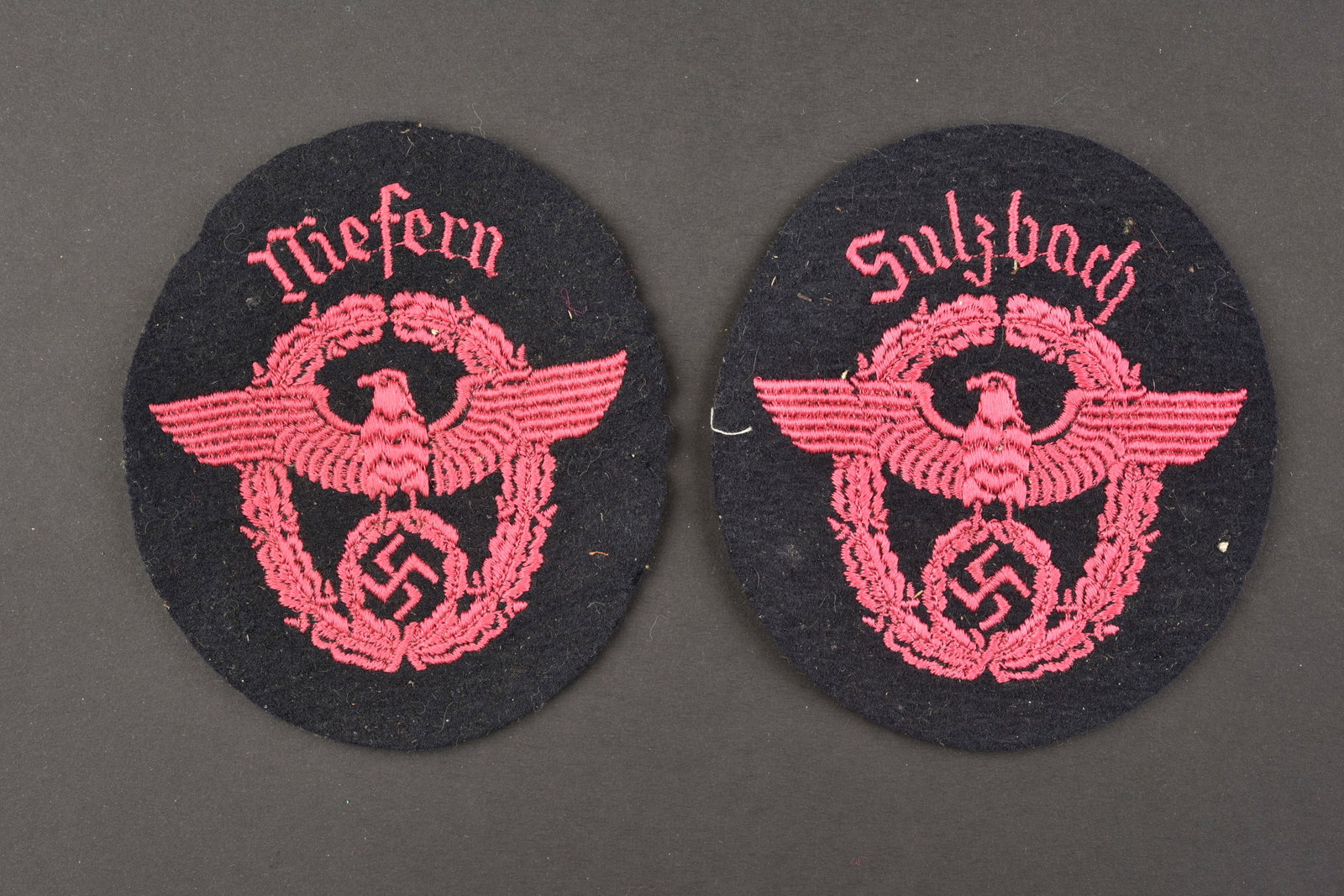 Insignes de manche de pompier. Fireman's sleeve badges.: Insignes de manche des pompiers du Reich. Comprenant un insigne en drap noir, broderie rose, marquee Sulzbach. Un insigne de manche en drap noir, broderie rose, marquee Mefern. A noter une certaine us
