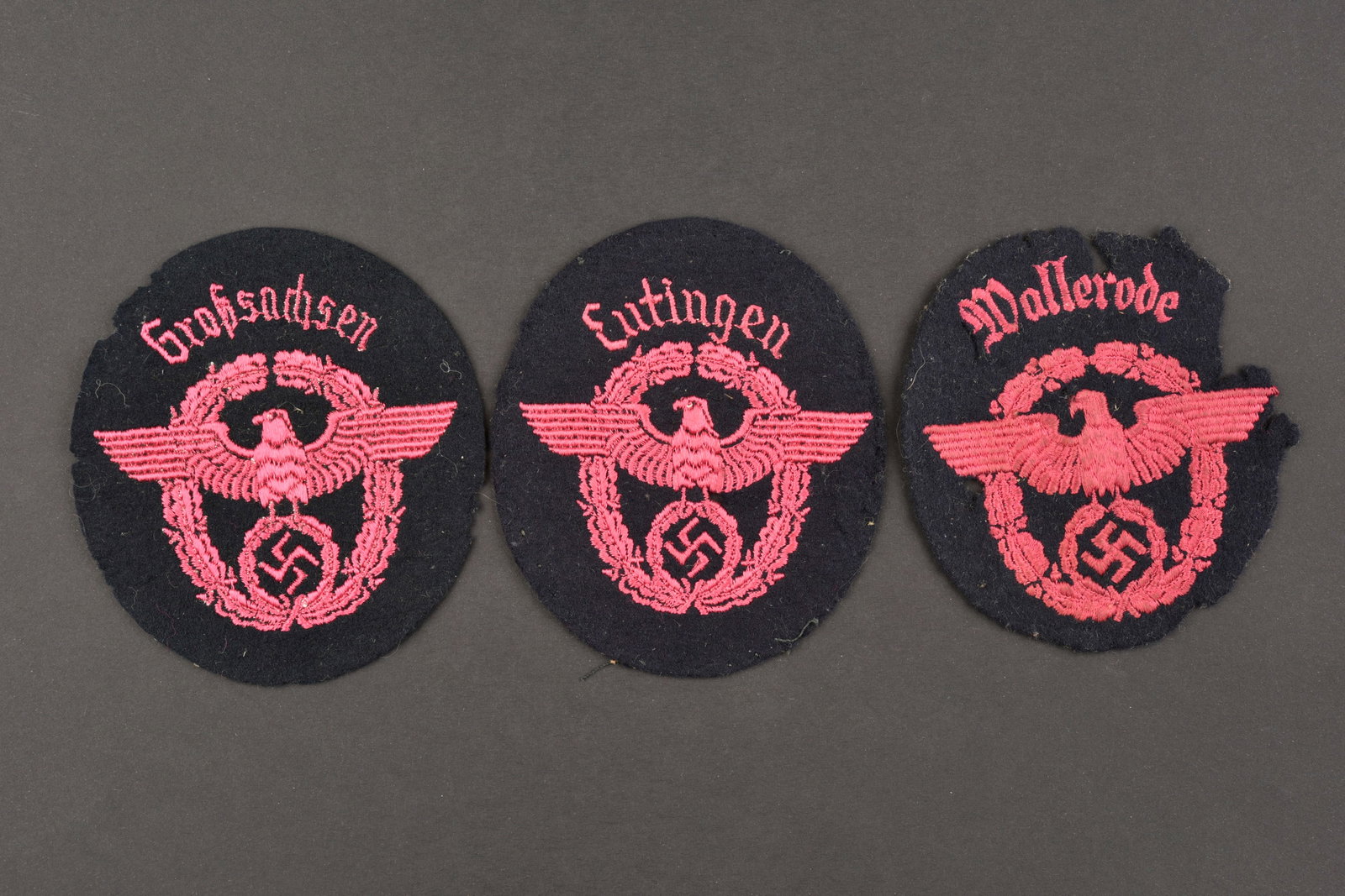Insignes de manche de pompier. Fireman's sleeve badges.: Insignes de manche des pompiers du Reich. Comprenant un insigne en drap noir, broderie rose, marquee Wallerode. Un insigne de manche en drap noir, broderie rose, marquee Grosssachsen. Un insigne de ma