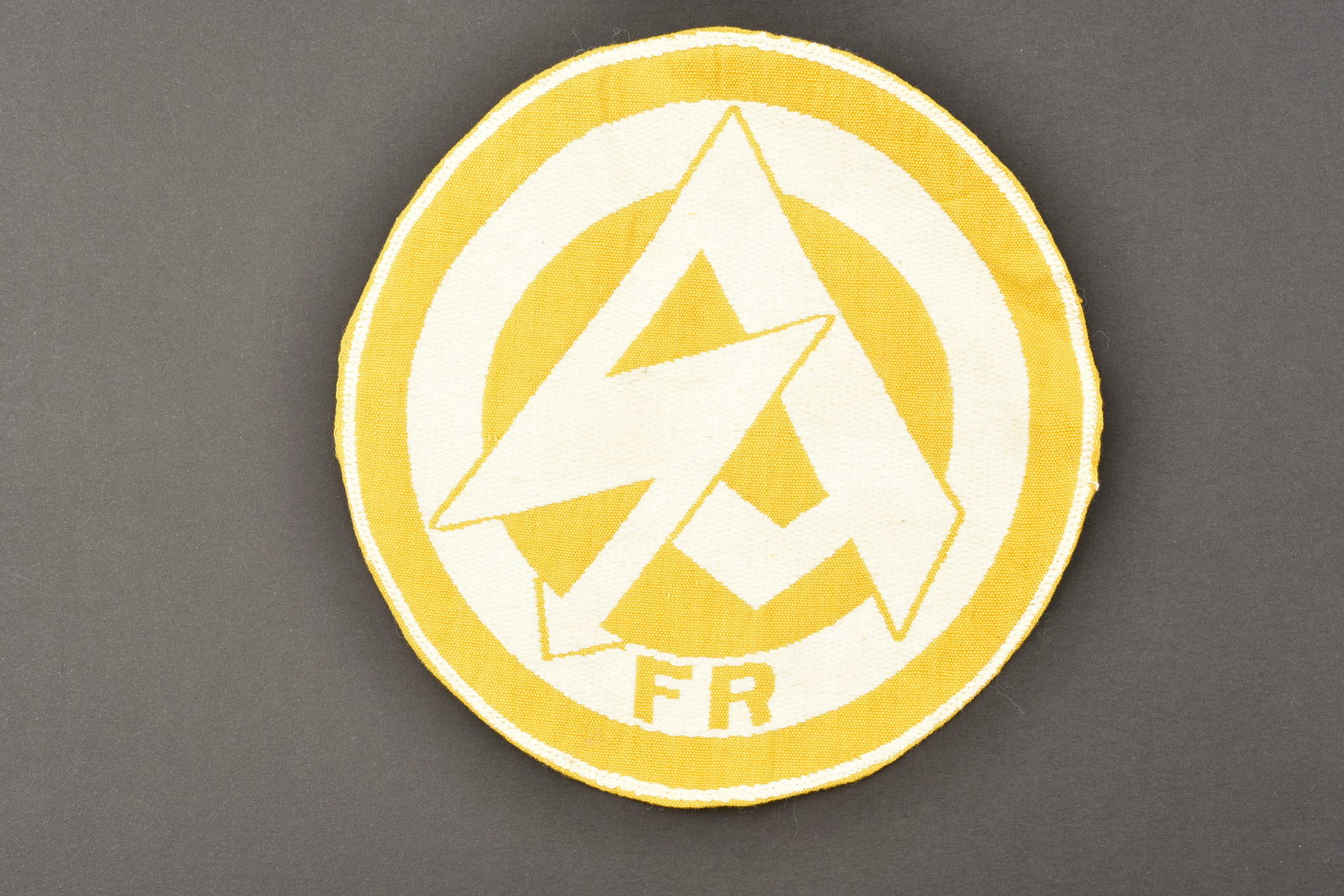 Insigne SA. SA insignia.: Insigne de maillot de sport SA. Modele tisse sur fond blanc, logo SA en tisse en jaune, lettrage FR. Jamais monte. Sans marquages visibles. Diametre 15 cm. Etiquette RZM absente. A noter une certaine 