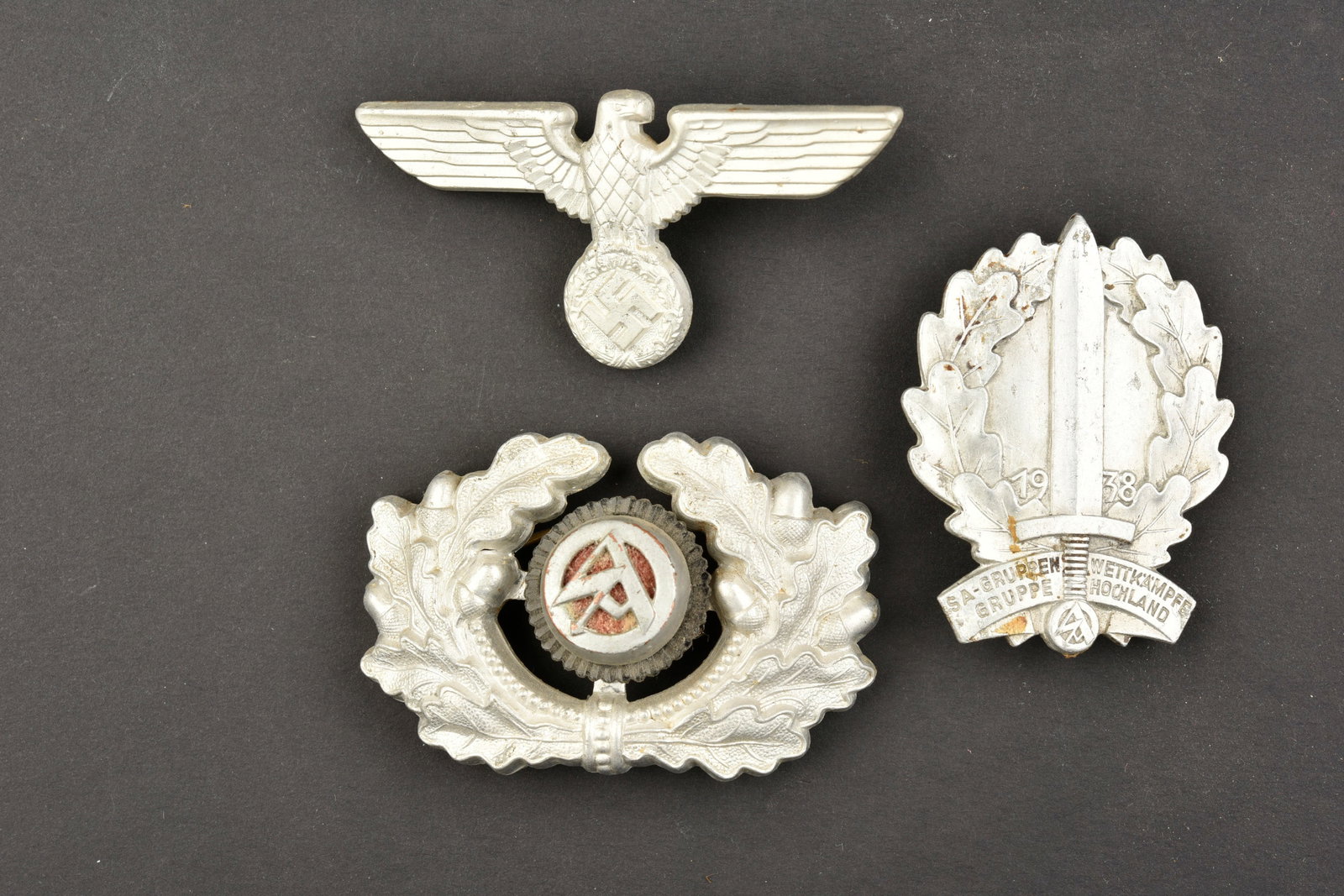 Insignes de coiffure SA. SA cap badges.: Insignes de coiffure SA. Comprenant un aigle en aluminium, une attache manquante, marquages RZM M1/47, correspondant au fabricant Christian Theodore Dicke, Ludenscheid. Une cocarde et feuilles de chen