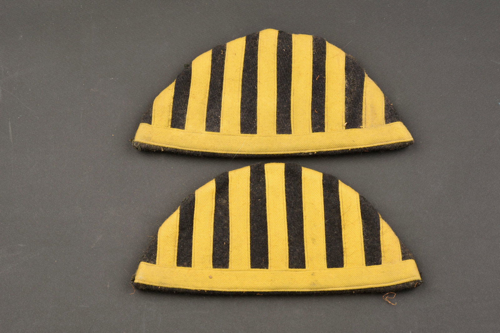 Nid d'hirondelle. Swallow's nest.: Nid d'hirondelle. En drap noir et galons jaune. Modele sans frange Dos des pieces double en drap bleu marine. Les crochets de fixation sont presents. Sans marquages visibles, paire homogene. A noter u