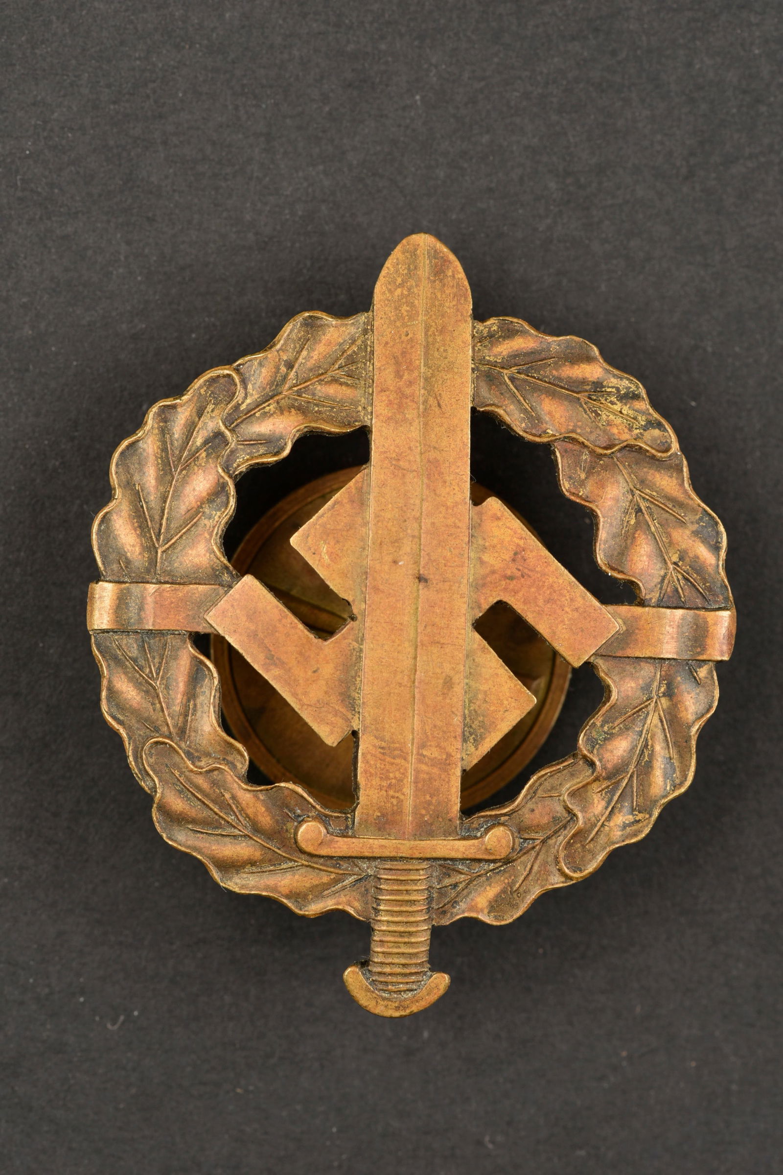 Badge des sports SA. SA sport insignia.: Badge des sports SA. Modele atypique, en metal, couleur bronze. Fermoir a vis. Sans marquages visibles. A noter une certaine usure et patine de la piece. Etat II+. Badge des sports SA. Atypical model