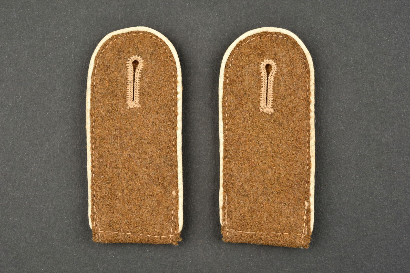 Pattes d'epaule SA Wehrmannschaft. Shoulder straps SA Wehrmanschaft.: Pattes d'epaule des SA Wehrmannschaft. Paire homogene en drap marron, lisere blanc. A noter une legere usure et patine des pieces. Etat I-. SA Wehrmannschaft shoulder straps. Homogeneous pair in brown