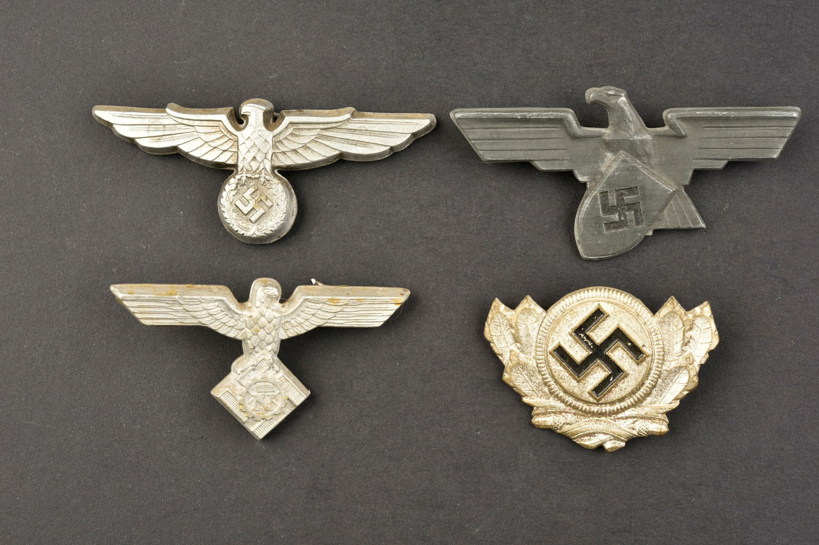 Insignes de coiffure. German cap insignia.: Insignes de coiffure. Comprenant un aigle de coiffure du Teno, les attaches sont presentes mais recollees. Un aigle de coiffure du Werkschutz, marquages Ges Gesch, les attaches sont presentes. Un aigl