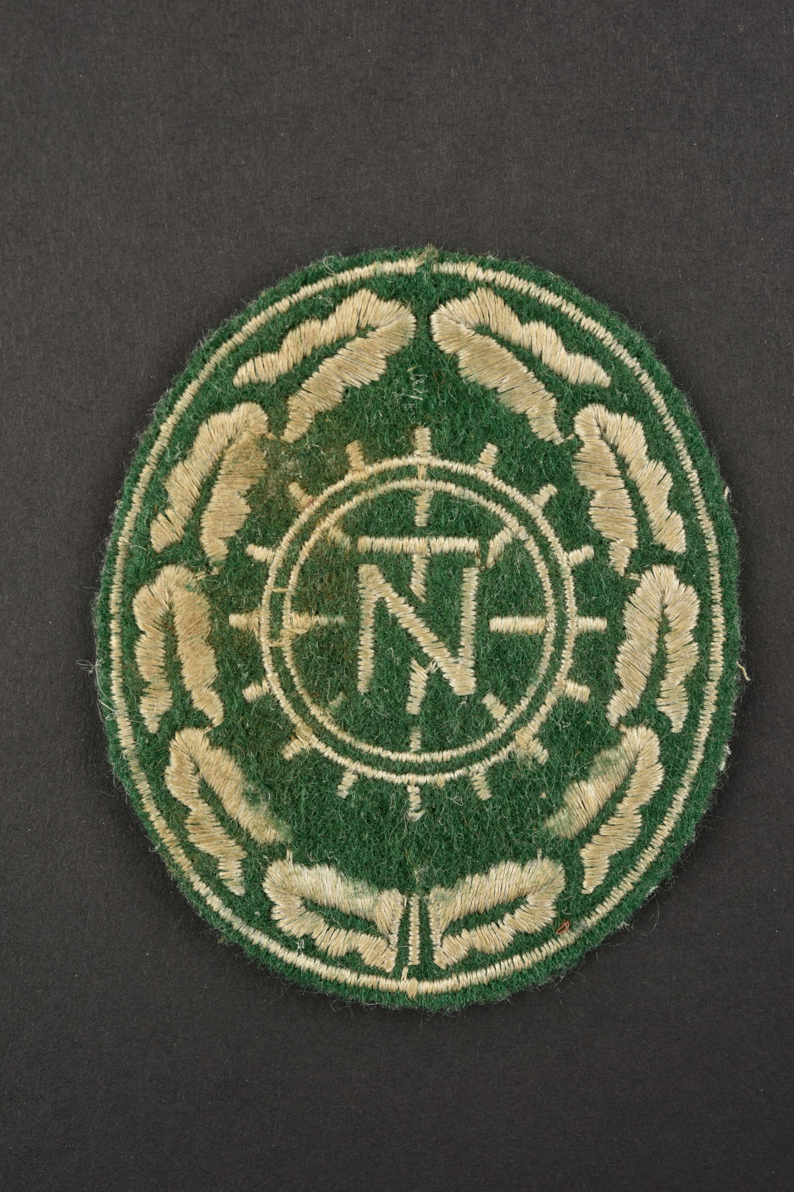 Insigne de manche du Teno. Teno sleeve insignia.: Insigne de manche du Teno. Modele brode sur fond en drap vert clair. Jamais monte. A noter une certaine usure et patine de la piece, ainsi que quelques taches. Etat II+. Teno sleeve badge. Embroidered