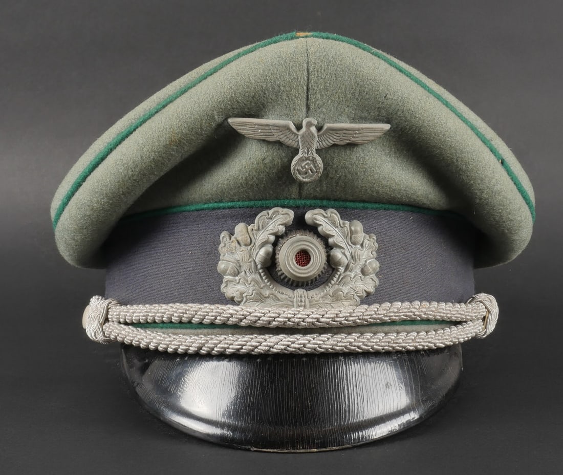 Casquette de Sonderfuhrer. Sonderfuhrer cap.: Casquette d officier Sonderfuhrer. En drap Feldgrau. Triple liser e vert fonc e. Bandeau en drap gris bleu. Insignes m etalliques. Les insignes n ont pas et e d emont es afin de v erifier les attaches