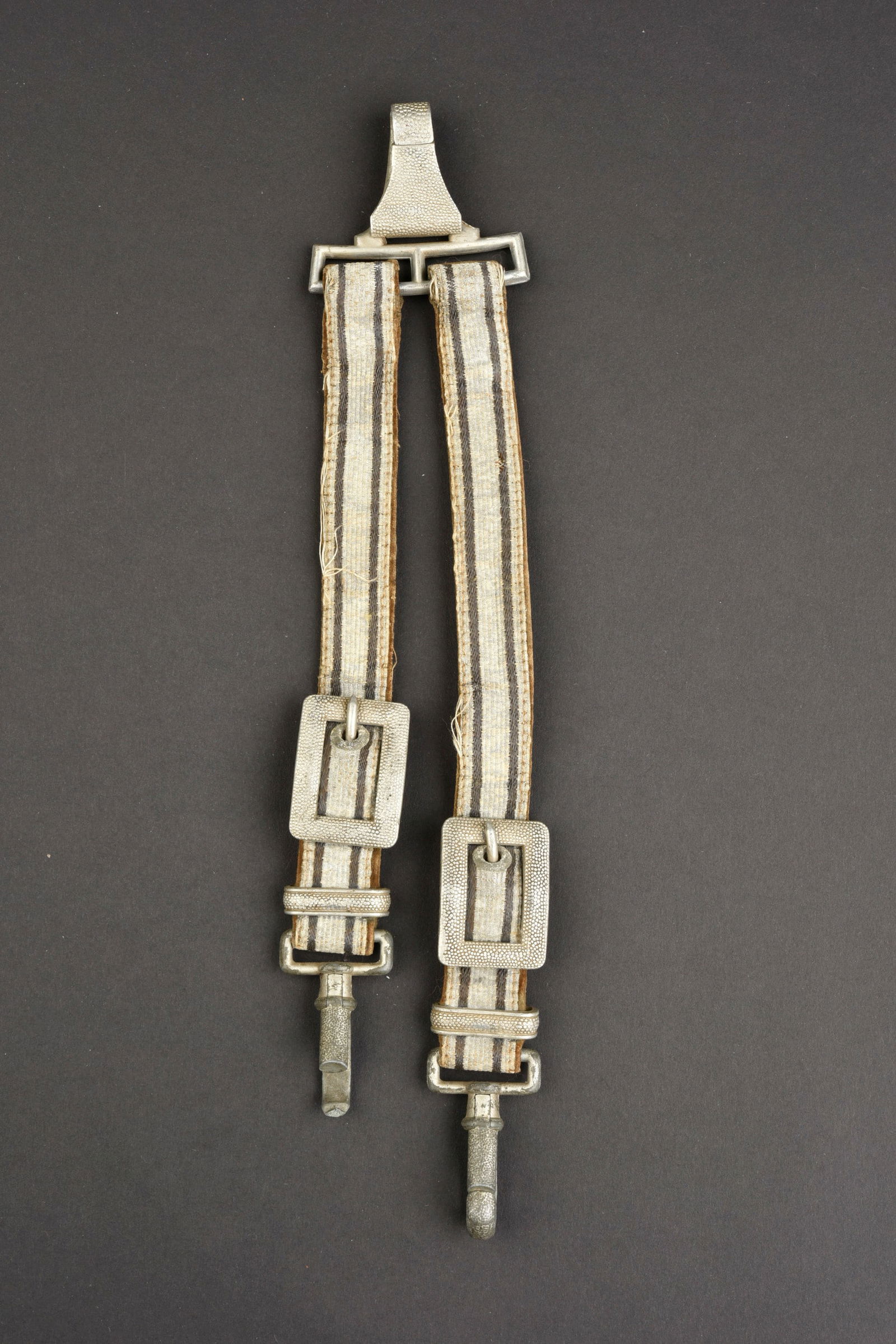 B eli ere de dague. Dagger hanger.: B eli ere de dague allemande. Galon argent et gris sur support en velours. Un mousqueton cass e. A noter une certaine usure et patine de la pi ece. Etat II+. German dagger hanger. Silver and gray brai