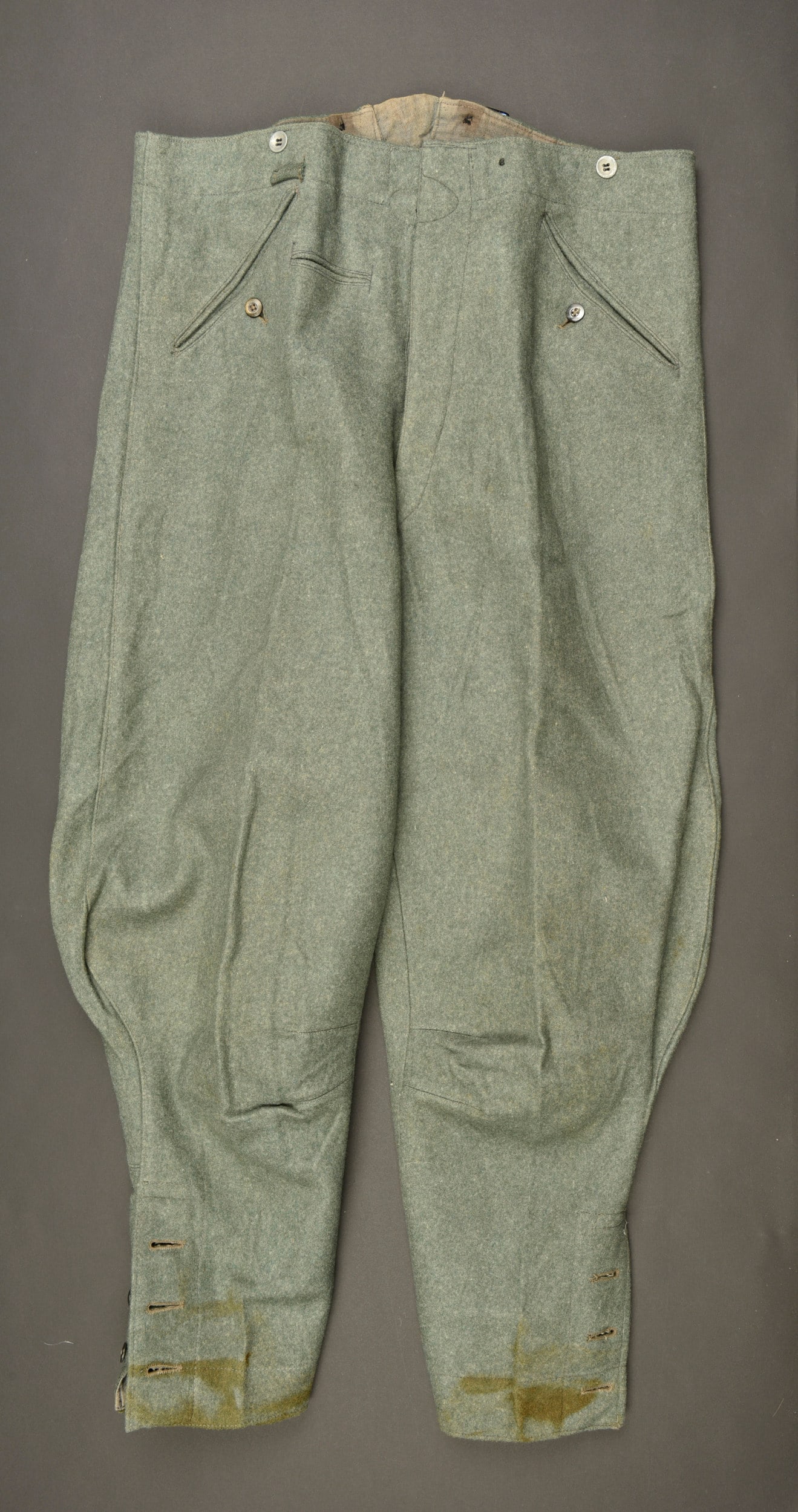 Pantalon culotte de cheval. German officer trousers.: Pantalon culotte de cheval. En drap Feldgrau. Tous les boutons sont pr esents. Bas des jambes fermant par trois boutons. Quelques taches au bas des jambes. Martingale pr esente et dans sa couleur d or