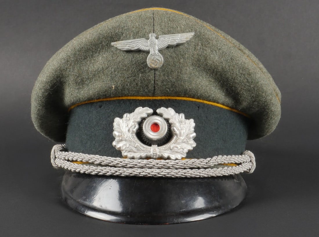 Casquette cavalerie. German cavalery cap.: Casquette d officier de cavalerie. En drap Feldgrau, triple liser e jaune d or. Bandeau en velours vert. Insignes m etalliques. Les insignes n ont pas et e d emont es afin de v erifier les attaches. F