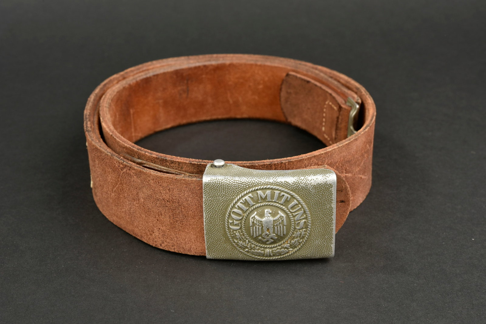 Ceinturon de la Heer. German belt.: Ceinturon de la Heer. Ceinturon en cuir marron. Bouclerie en m etal, fabrication OLC. Patte de r eglage pr esente. Taille 98. Marquages illisibles. Boucle de ceinturon en aluminium grenel e. Reste de 