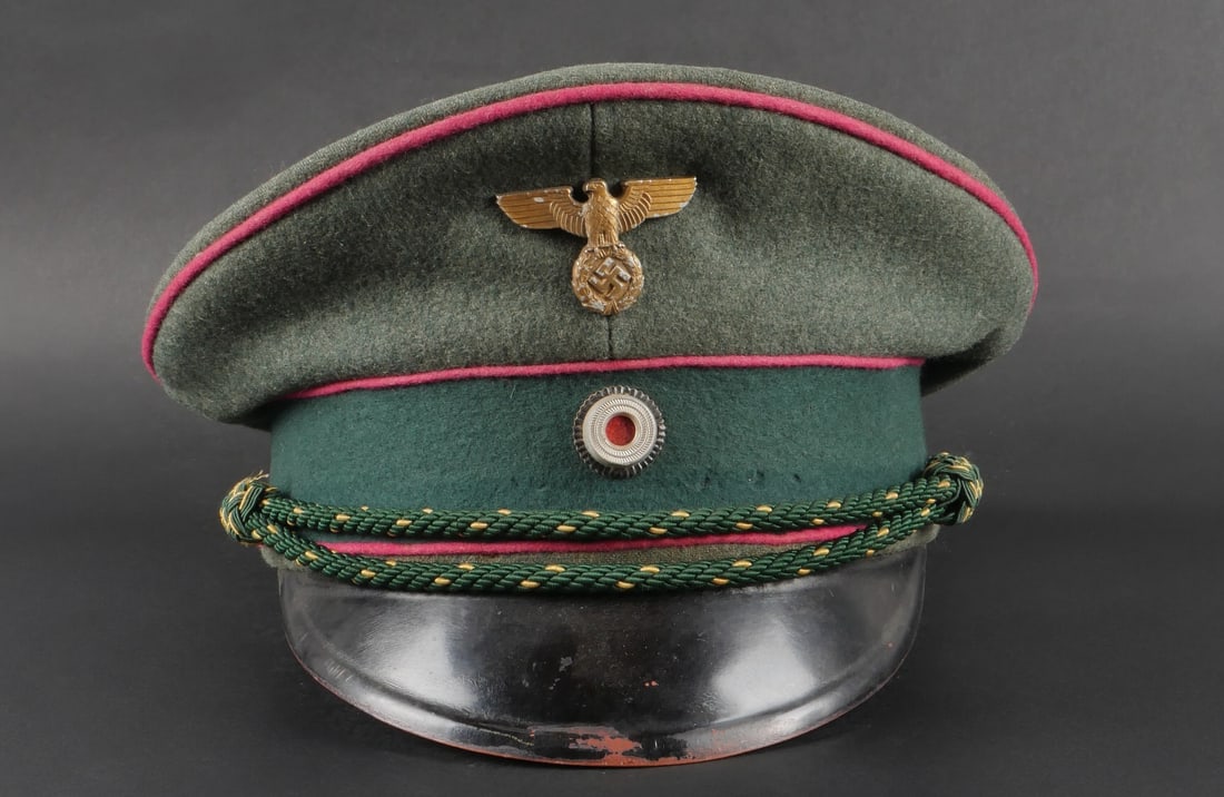 Casquette de gardien de prison. Prison guard cap.: Casquette de gardien de prison. En drap Feldgrau. Triple liser e rose. Bandeau en drap vert fonc e. Insignes m etalliques. Les insignes n ont pas et e d emont es afin de v erifier les attaches. Fausse
