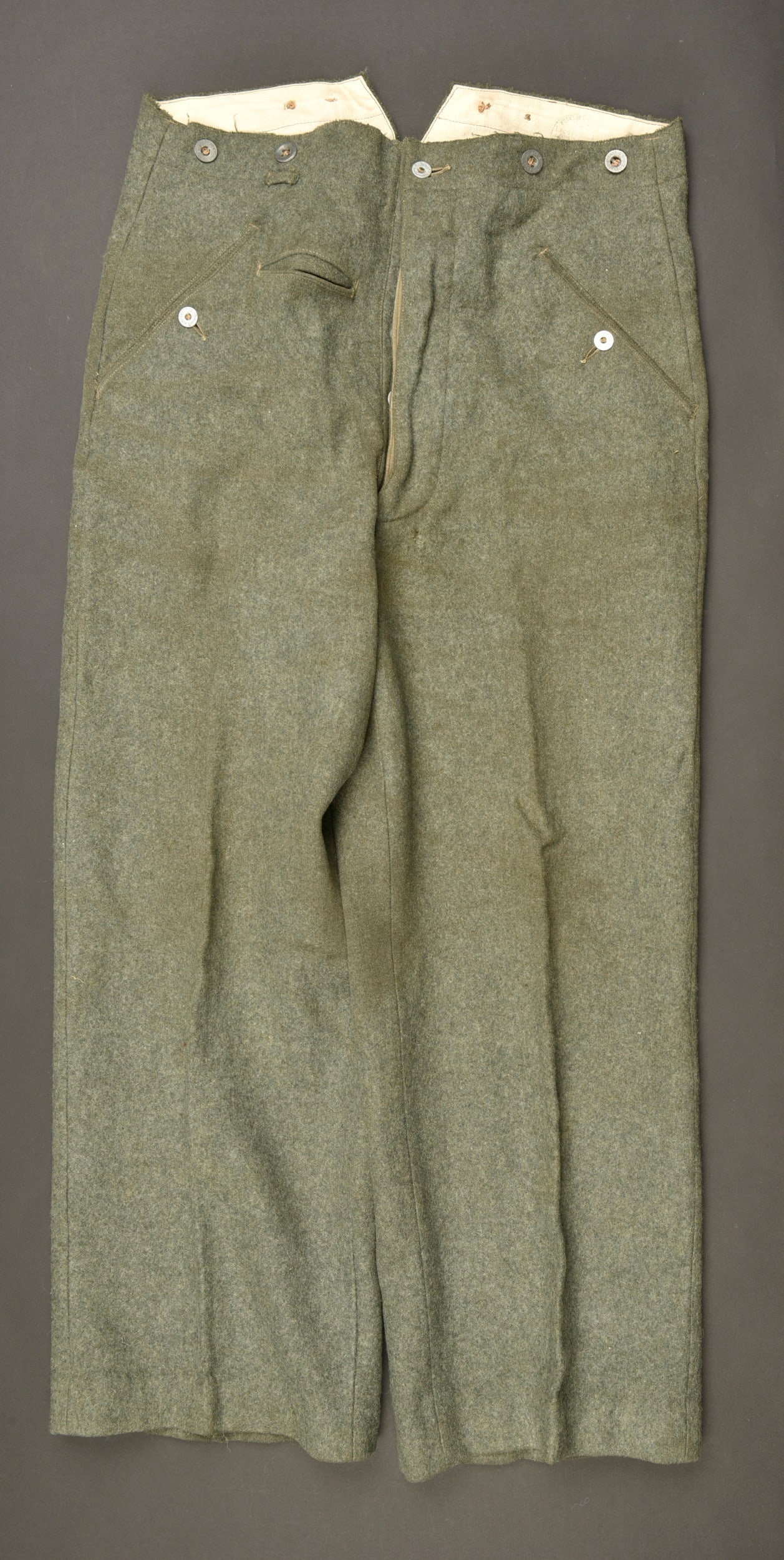 Pantalon allemand. German trousers.: Pantalon allemand. En drap Feldgrau. Tous les boutons sont pr esents, certains sont marqu es Equipements militaires. Marquages 82 76, tampon francais illisibles. Indication nominative H Thier N10765/4