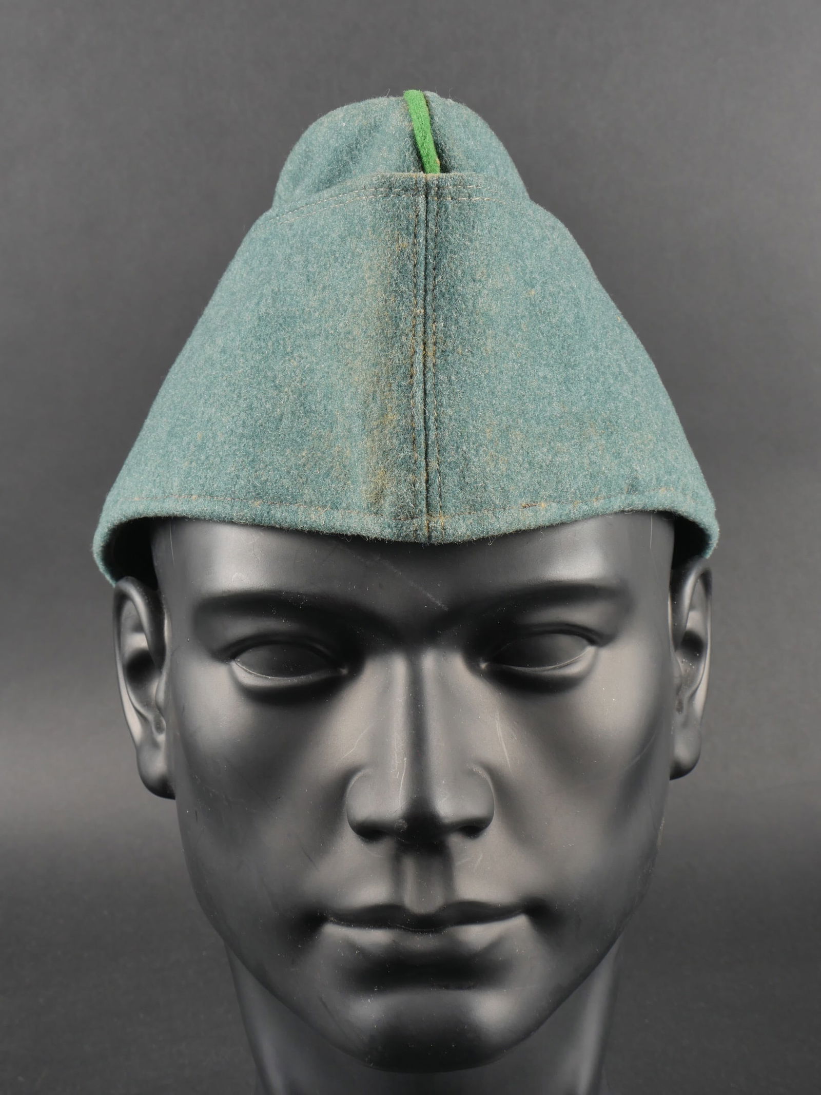 Calot Polizei. Police cap.: Calot Polizei. En drap gris vert. Liser e vert au niveau sup erieur de la coiffure. Sans insignes. Deux œillets d a eration. Int erieur doubl e en tissu marron. Marquages au tampon S Ko, taille 62. A