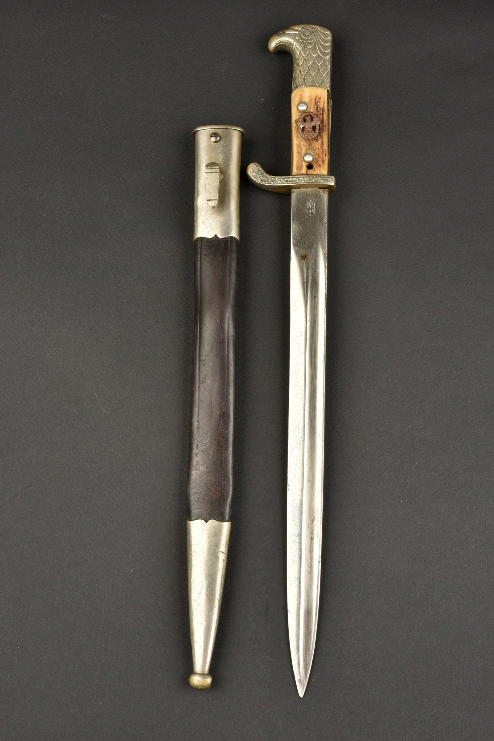 Baionnette Polizei. Polizei bayonet.: Baionnette Polizei. Pommeau a t ete d aigle finement cisel e. Plaquette en imitation corne. Insigne Polizei recoll e, il semble que ce ne soit pas l insigne d origine. Garde a d ecors de feuilles de c