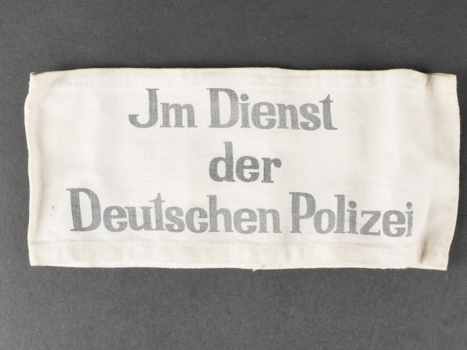 Brassard Polizei. Police armband.: Brassard Deutschen Polizei. En tissu coton blanc. Marquages imprim es Im Dienst der Deutschen Polizei. Sans marquages fabricant visibles. A noter une certaine usure et patine de la pi ece, ainsi que q
