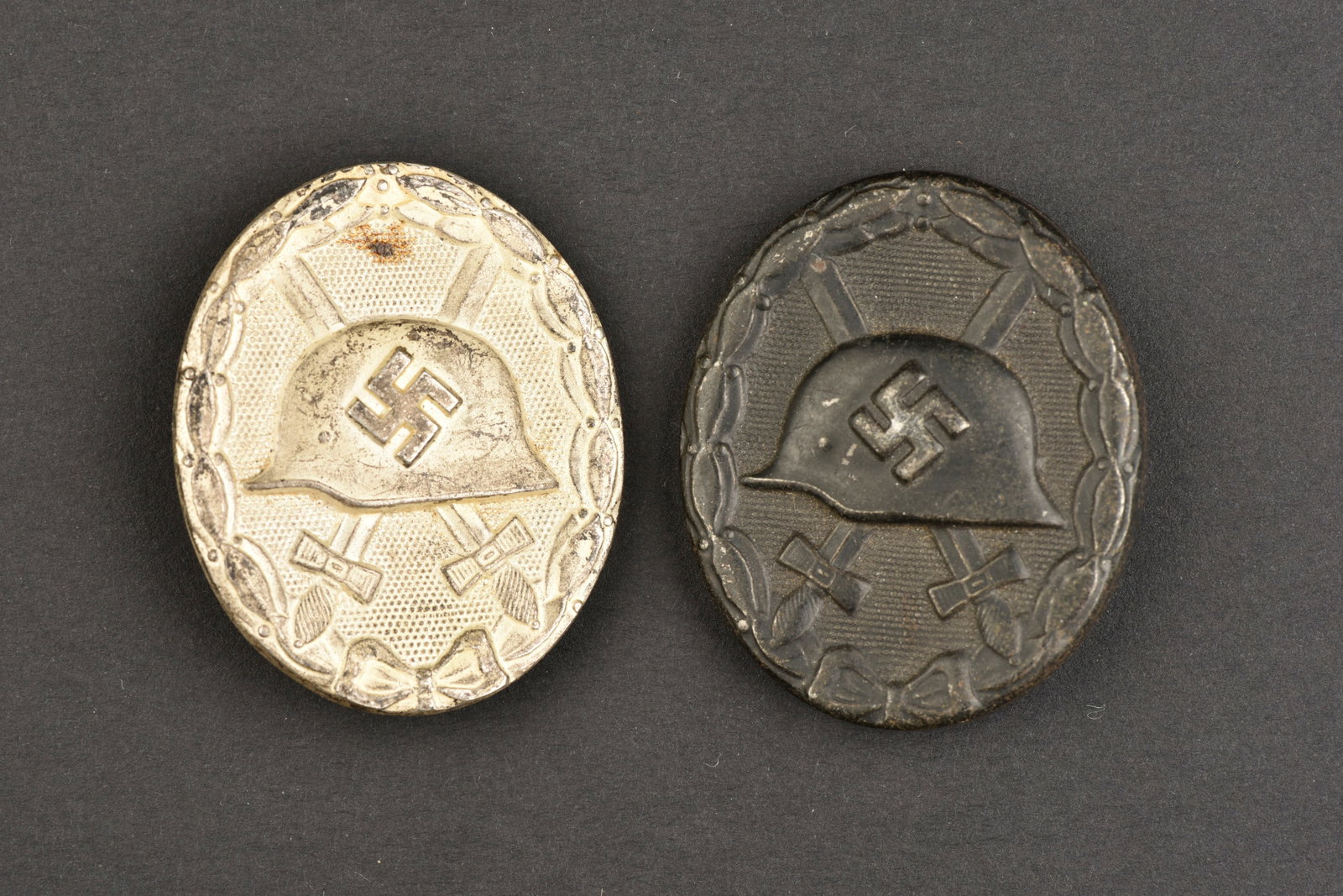 Insignes des bless es. German wounded badge.: Insignes des bless es. Comprenant un insigne des bless es noir, fabrication en creux, couleur noire a 80%, attache compl ete, fabrication ESP. Un insigne des bless es argent, couleur argent a 80%, att
