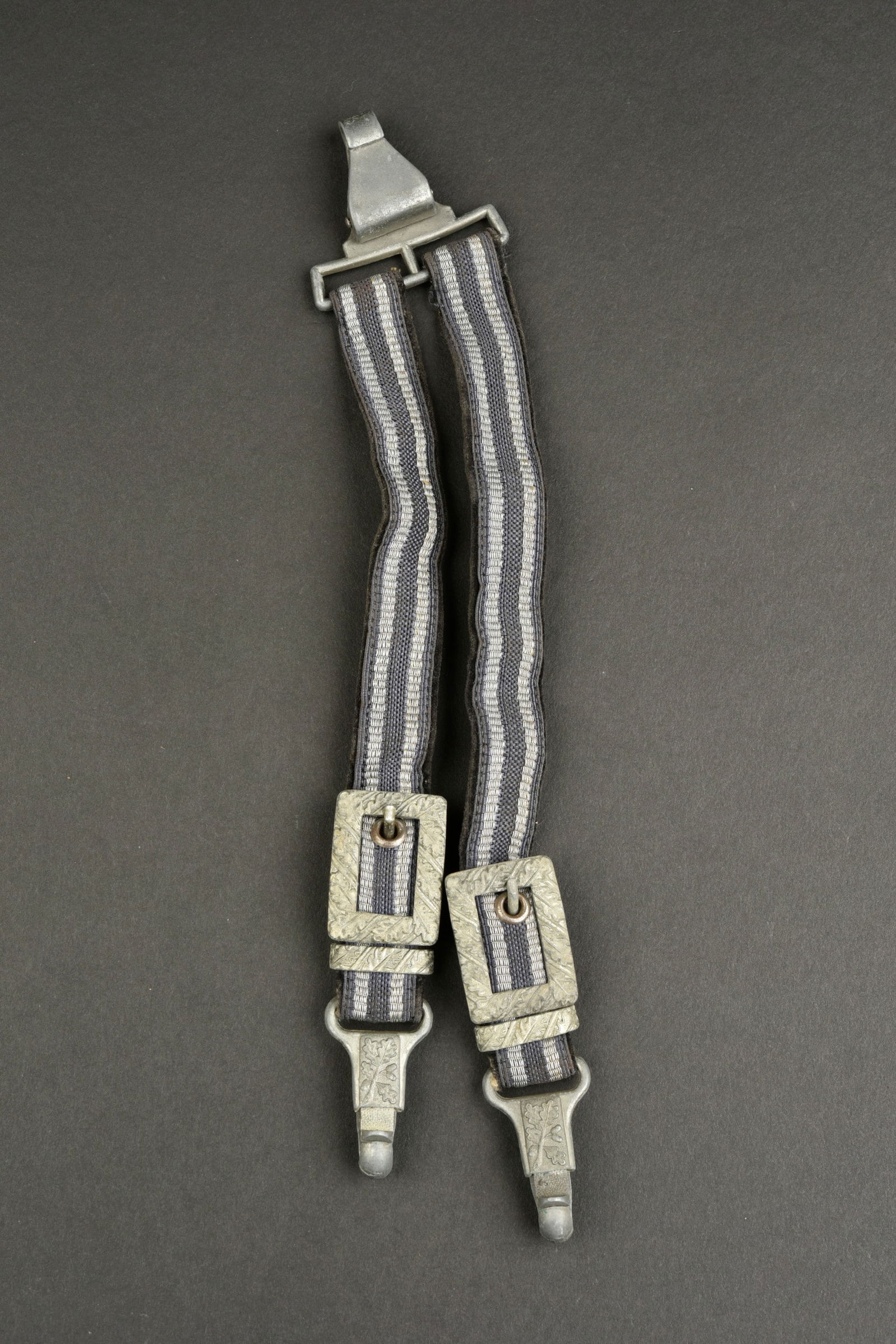 B eli eres LW. Luftwaffe dagger straps.: B eli eres de la Luftwaffe. En tissu gris/bleu et liser e argent. Parties m etalliques a d ecors de feuilles de ch ene. Mousquetons fonctionnels. Sans marquages visibles. A noter une l eg ere usure et